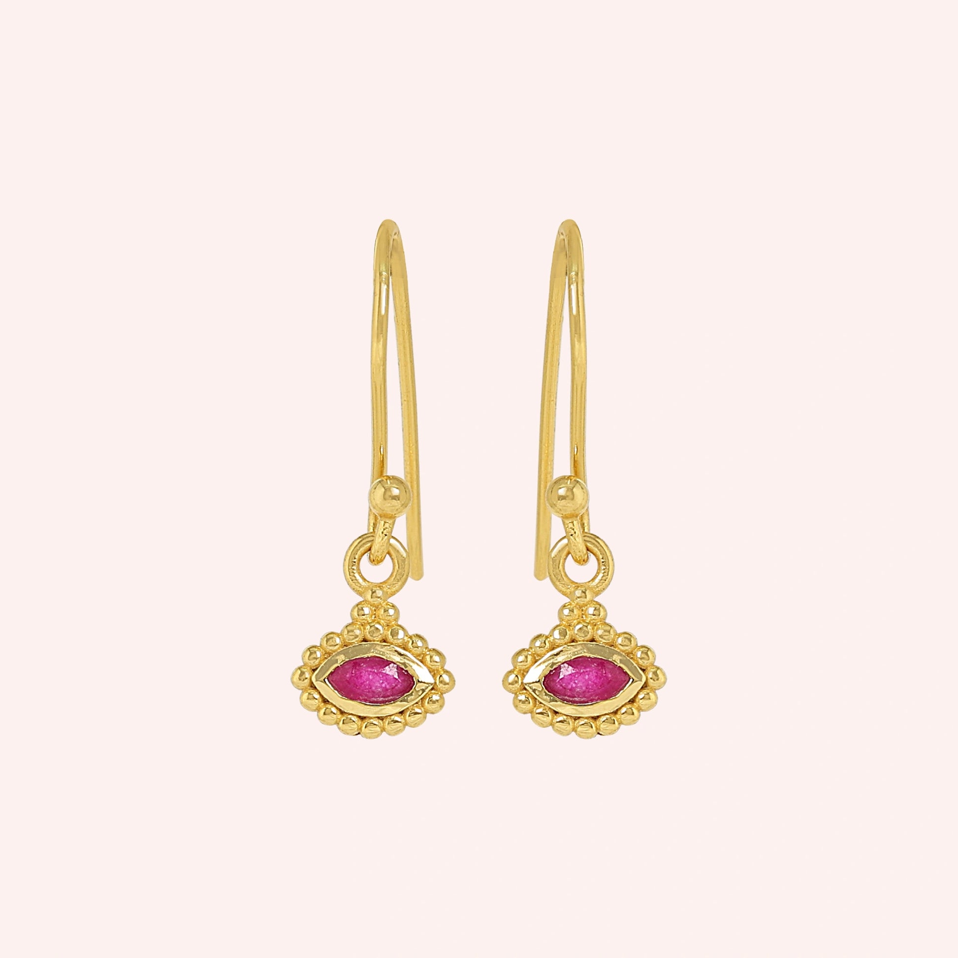 Ruby_earrings_in_gold_plated_silver_with_marquise_ruby_stone_at_frontt_angle_view_on_solid_pink_background