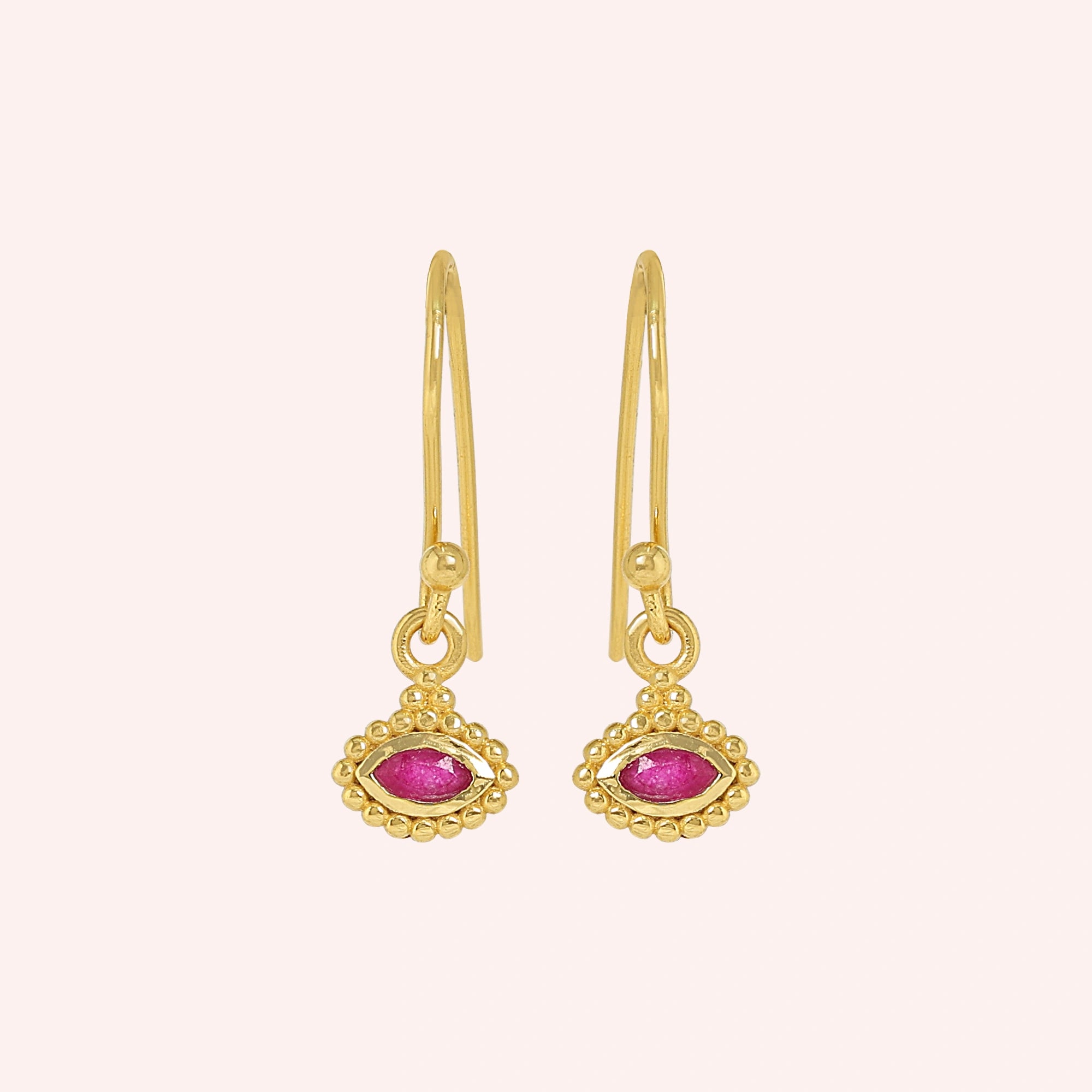 Ruby_earrings_in_gold_plated_silver_with_marquise_ruby_stone_at_frontt_angle_view_on_solid_pink_background