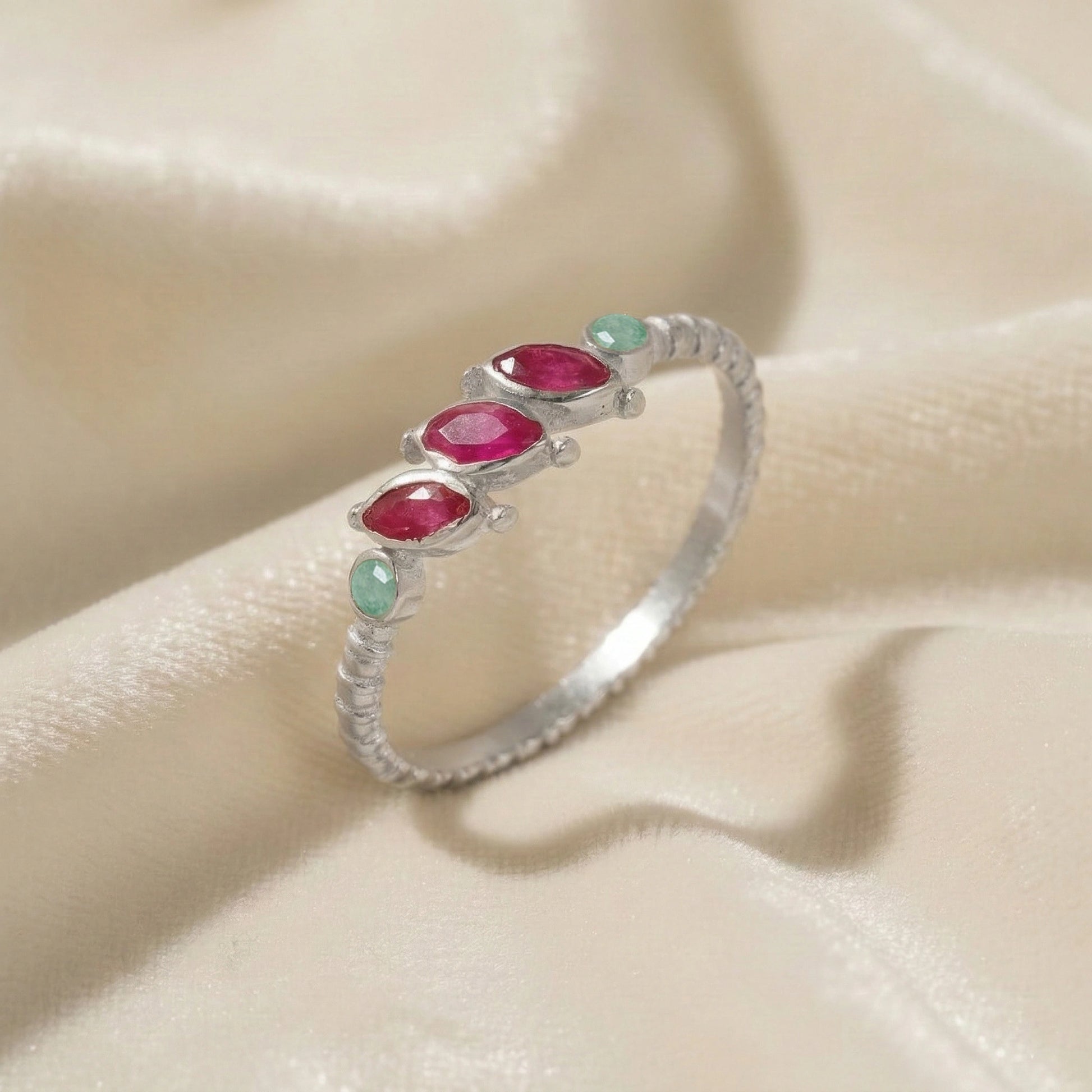 Ruby-ring-with-pink-and-green-gemstones-sterling-silver-angled-view-on-white-satin-background
