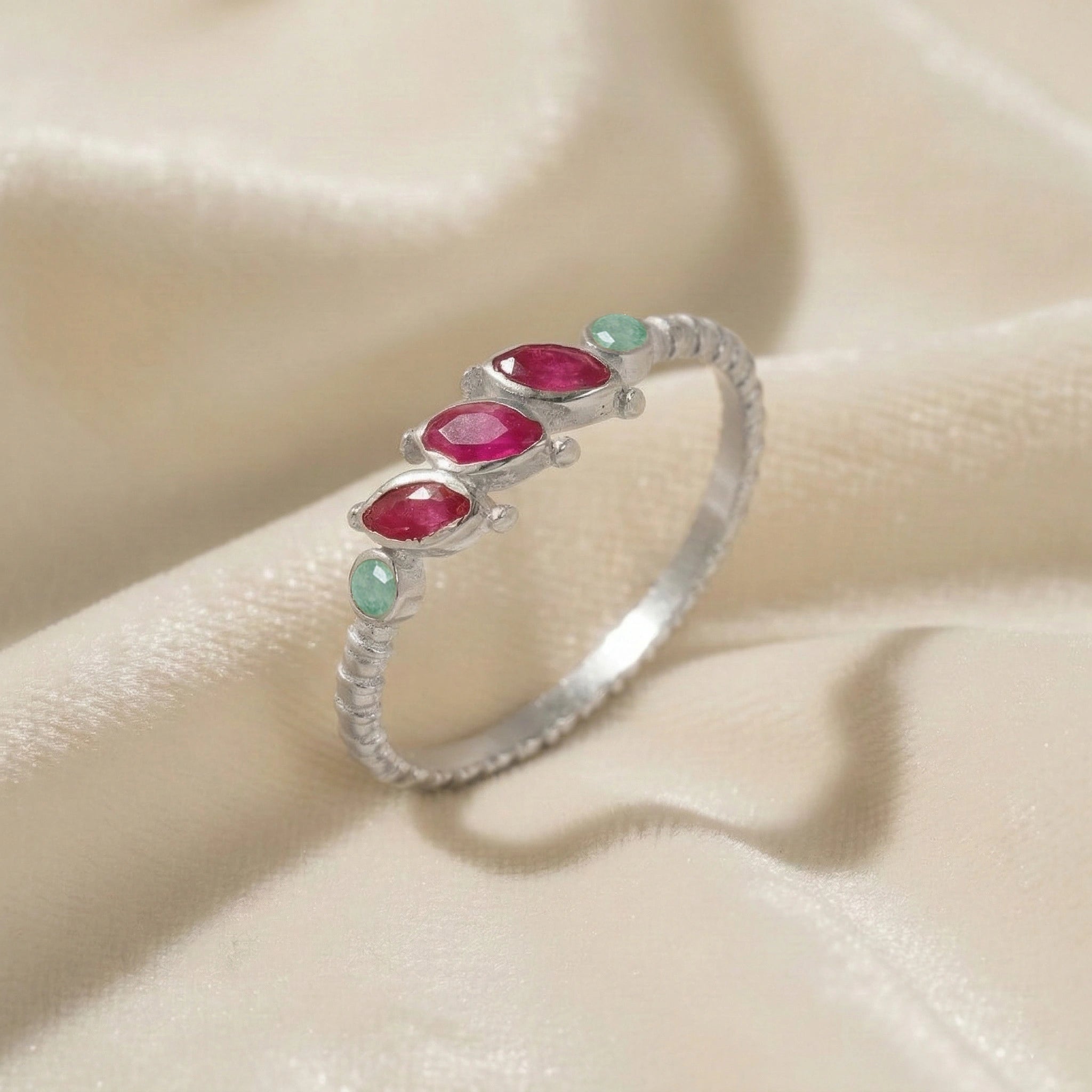 Ruby-ring-with-pink-and-green-gemstones-sterling-silver-angled-view-on-white-satin-background