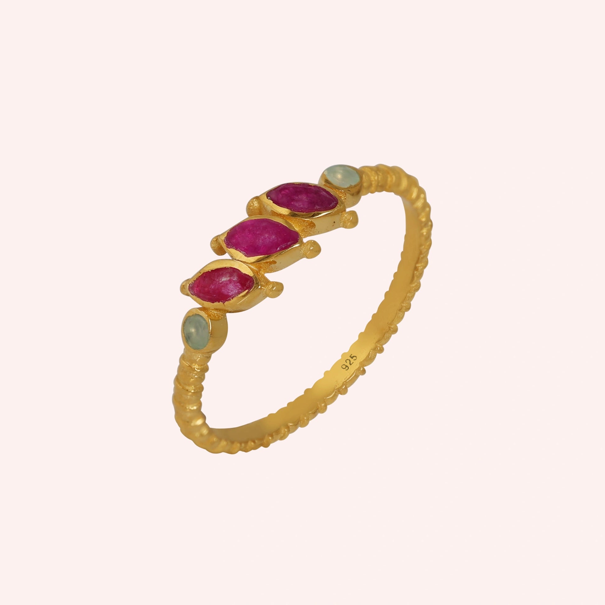 Ruby-ring-with-pink-and-green-gemstones-gold-plated-silver-angled-view-on-solid-pink-background