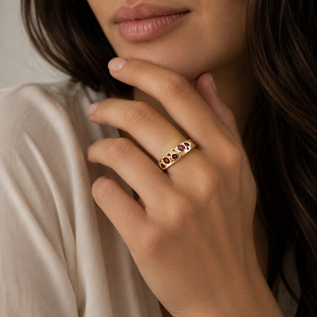 Ruby_stone_ring_in_gold_plated_silver_with_multiple_ruby_stones_at_slight_angle_on_soft_fabric_background