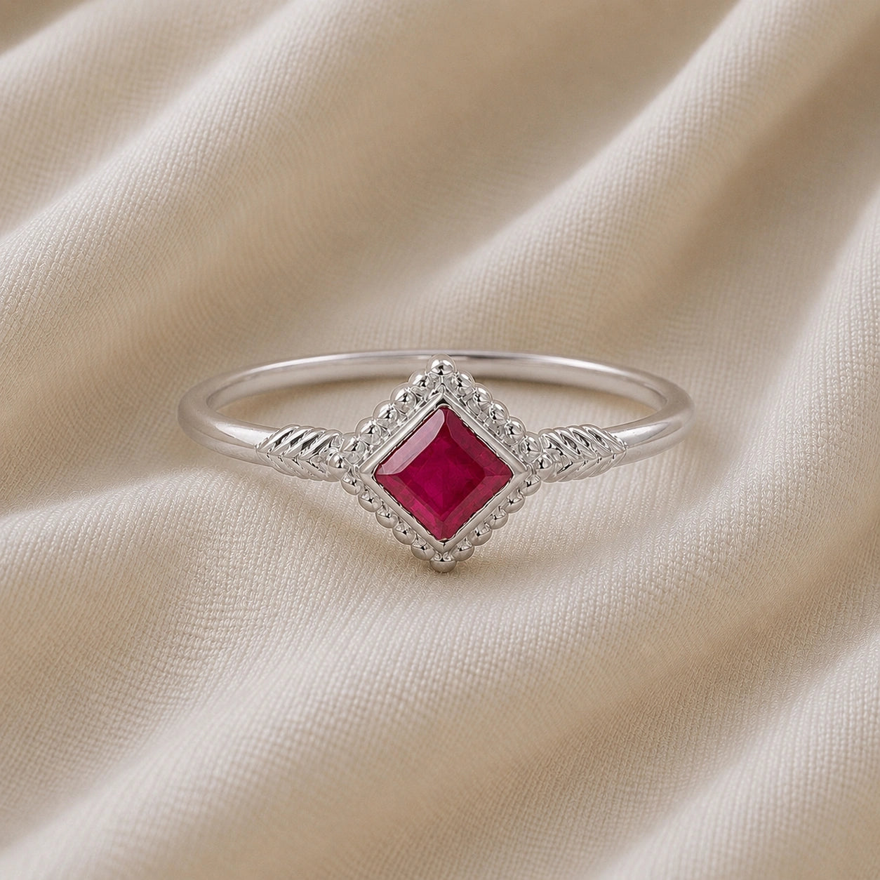 Princess_cut_ring_gold_plated_silver_with_square_ruby_and_detailed_band_front_angle_view_on_soft_fabric_background