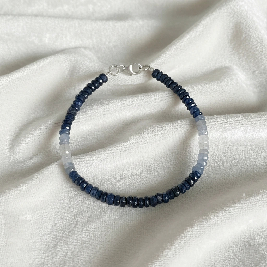 Sapphire_bracelet_in_ombre_effect_with_sapphire_stones_in_gradient_design_in_front_angle_on_a_white_fabric_background