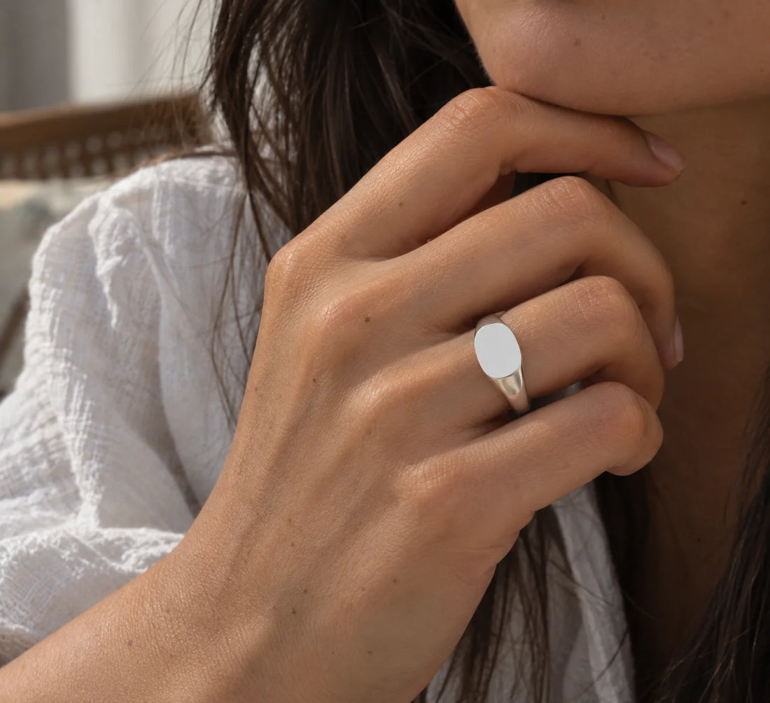 Signet_ring_in_gold_plated_silver_with_at_front_angle_view_on_soft_fabric_background