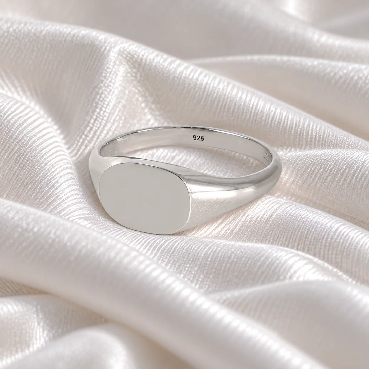 Signet_ring_in_sterling_silver_with_at_slightly_angle_view_on_soft_fabric_background