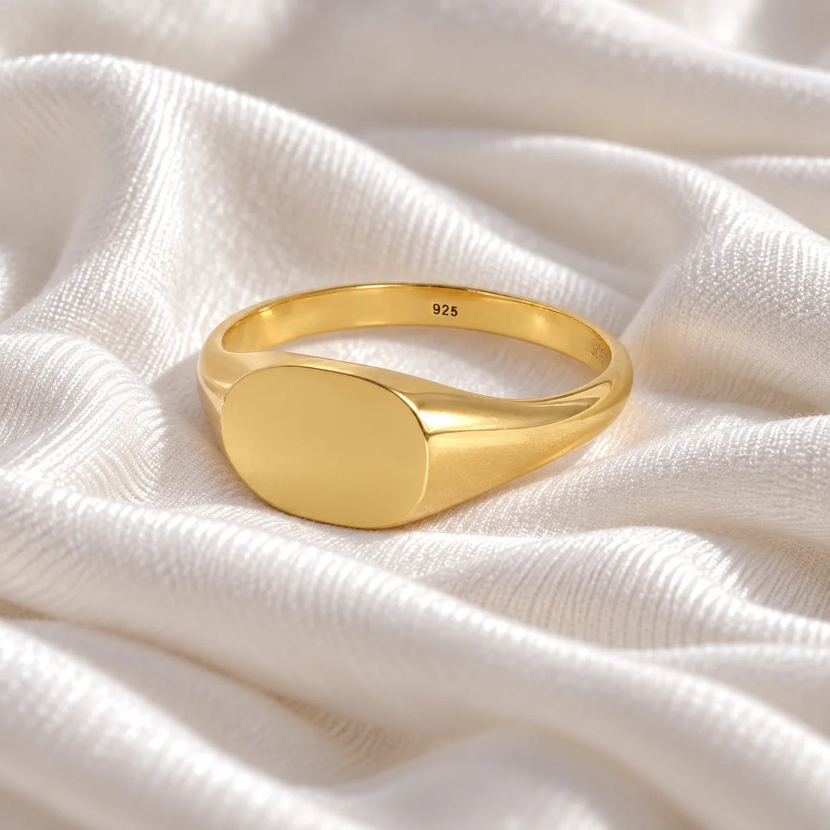 Signet_ring_in_gold_plated_silver_with_at_slightly_angle_view_on_soft_fabric_background