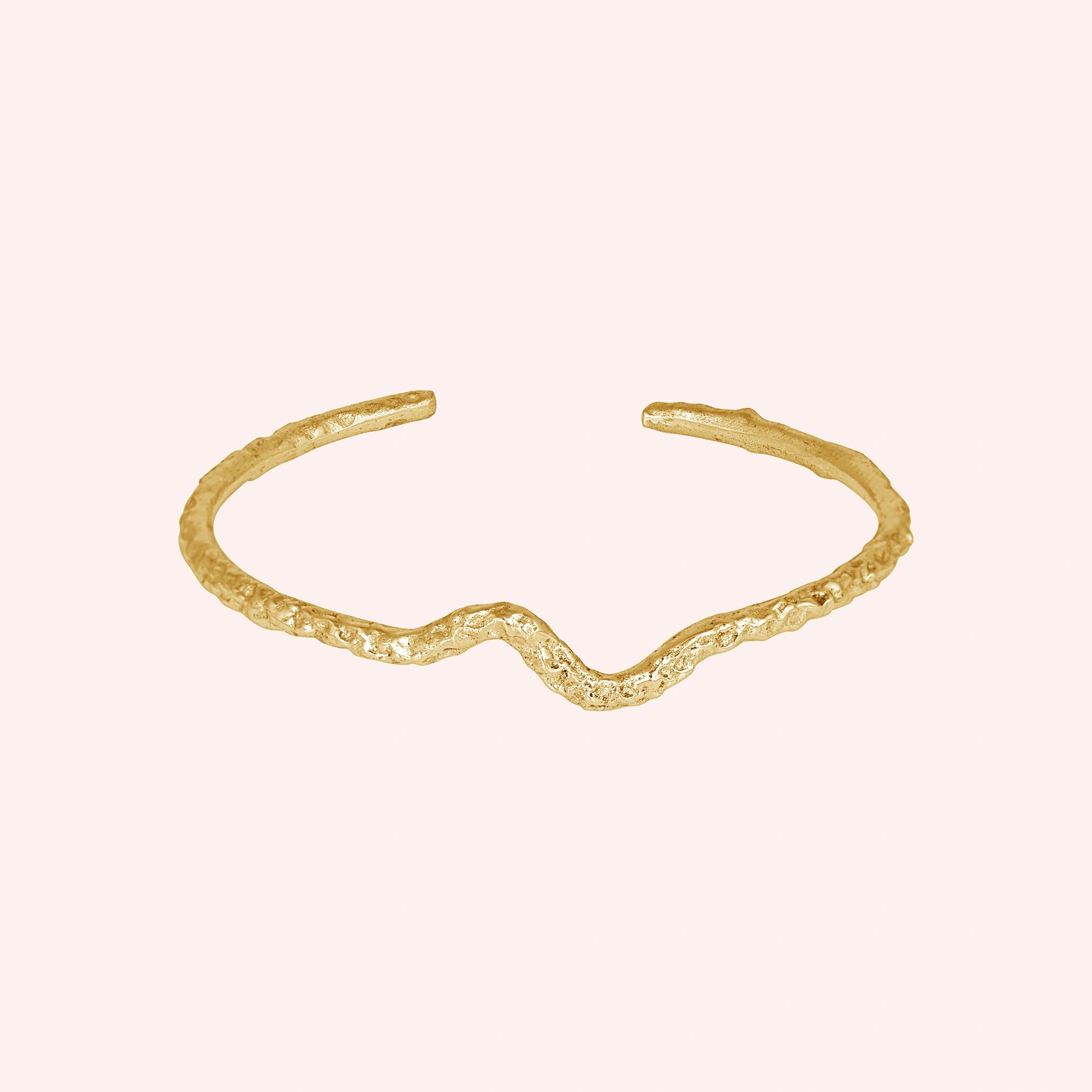 Silver cuff bracelet shown at front angled view featuring gold plated textured open cuff design displayed on a pink background