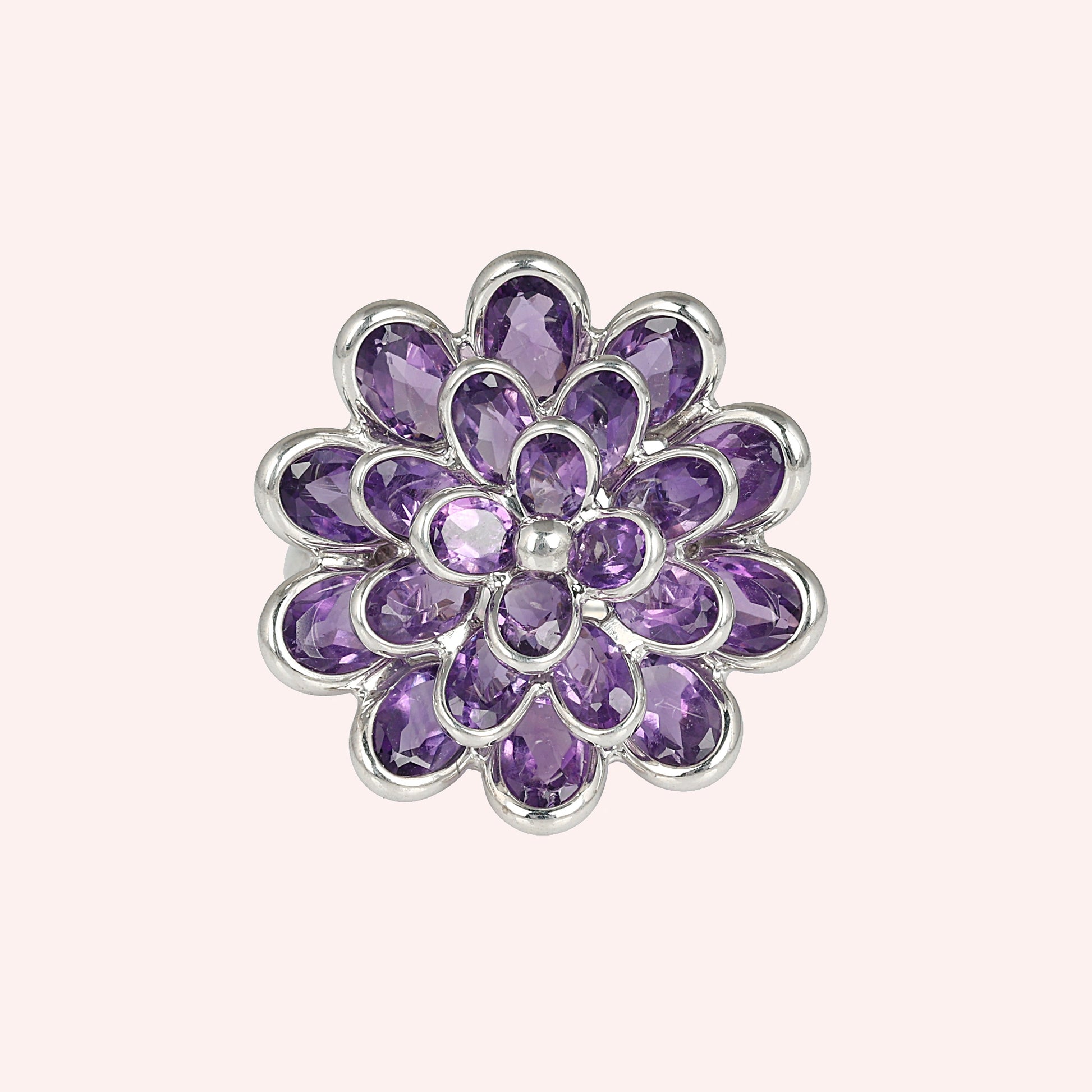 silver_flower_ring_flower_engagement_ring_top_view_with_purple_gem_petals_in_silver_setting_on_soft_pink_background