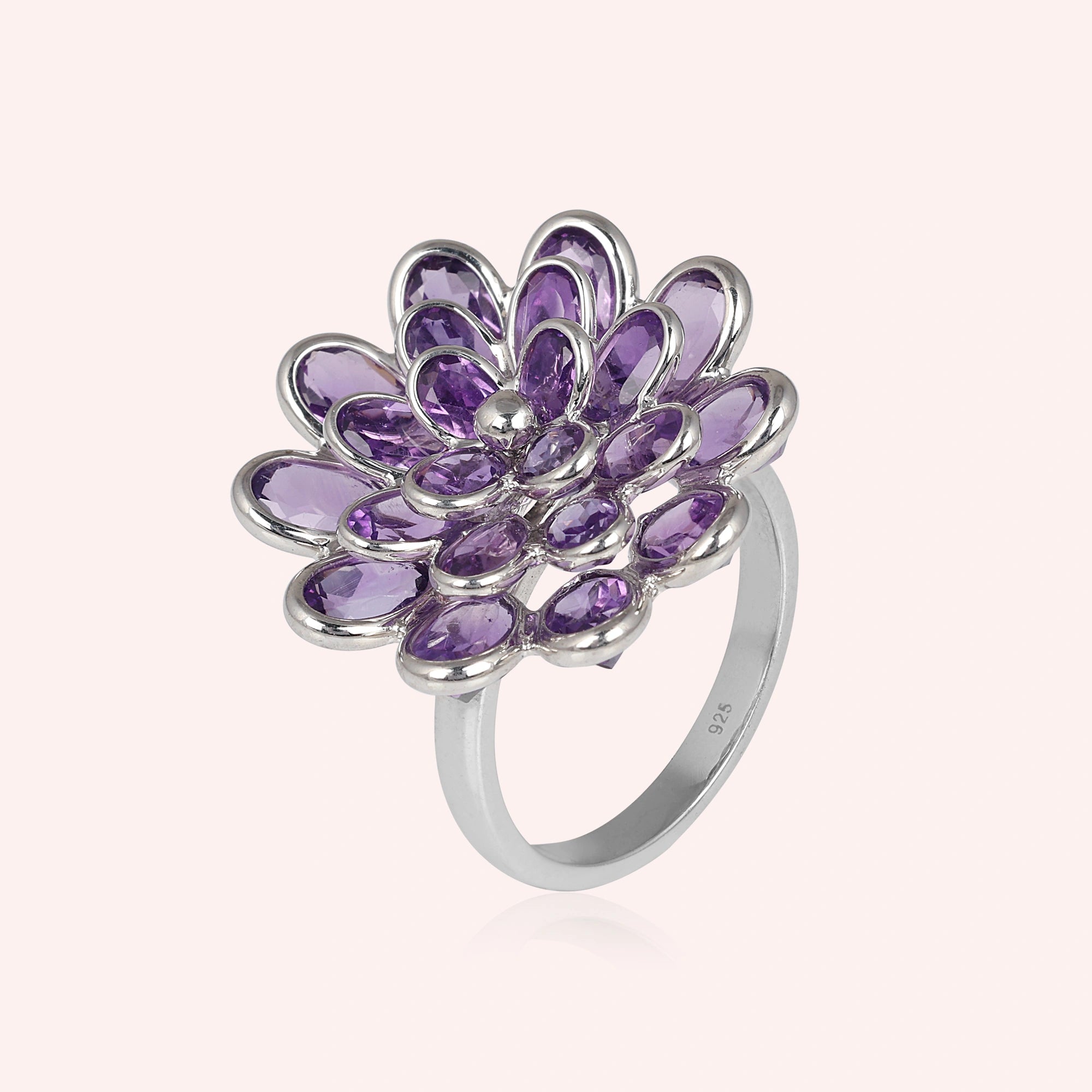 silver_flower_ring_flower_engagement_ring_with_purple_gem_petals_in_silver_setting_angled_view_on_soft_pink_background_clean