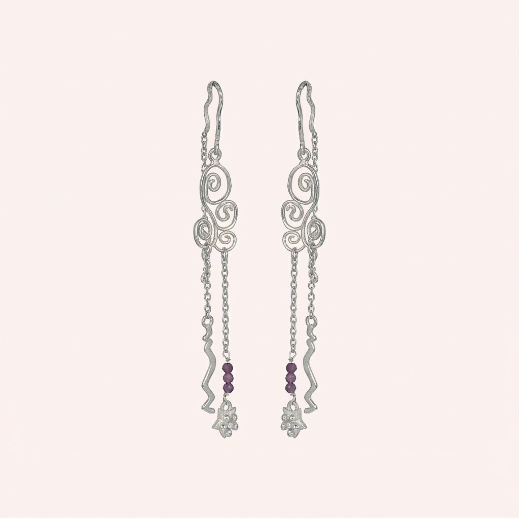 front_angle_silver_hanging_earrings_with_scroll_design_and_purple_beads_highlighting_trendy_earrings_on_soft_blush_background