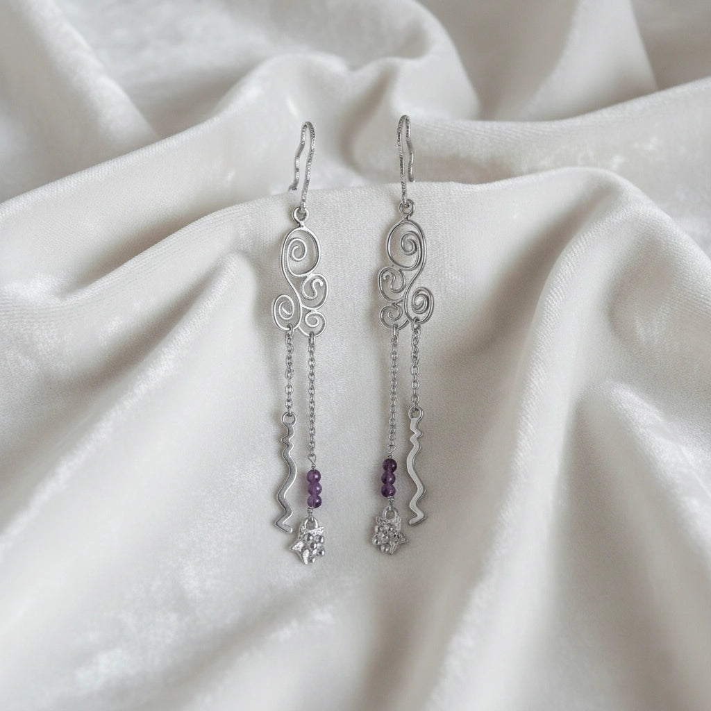 front_angle_silver_hanging_earrings_with_scroll_links_and_purple_beads_trendy_earrings_on_soft_white_fabric_background