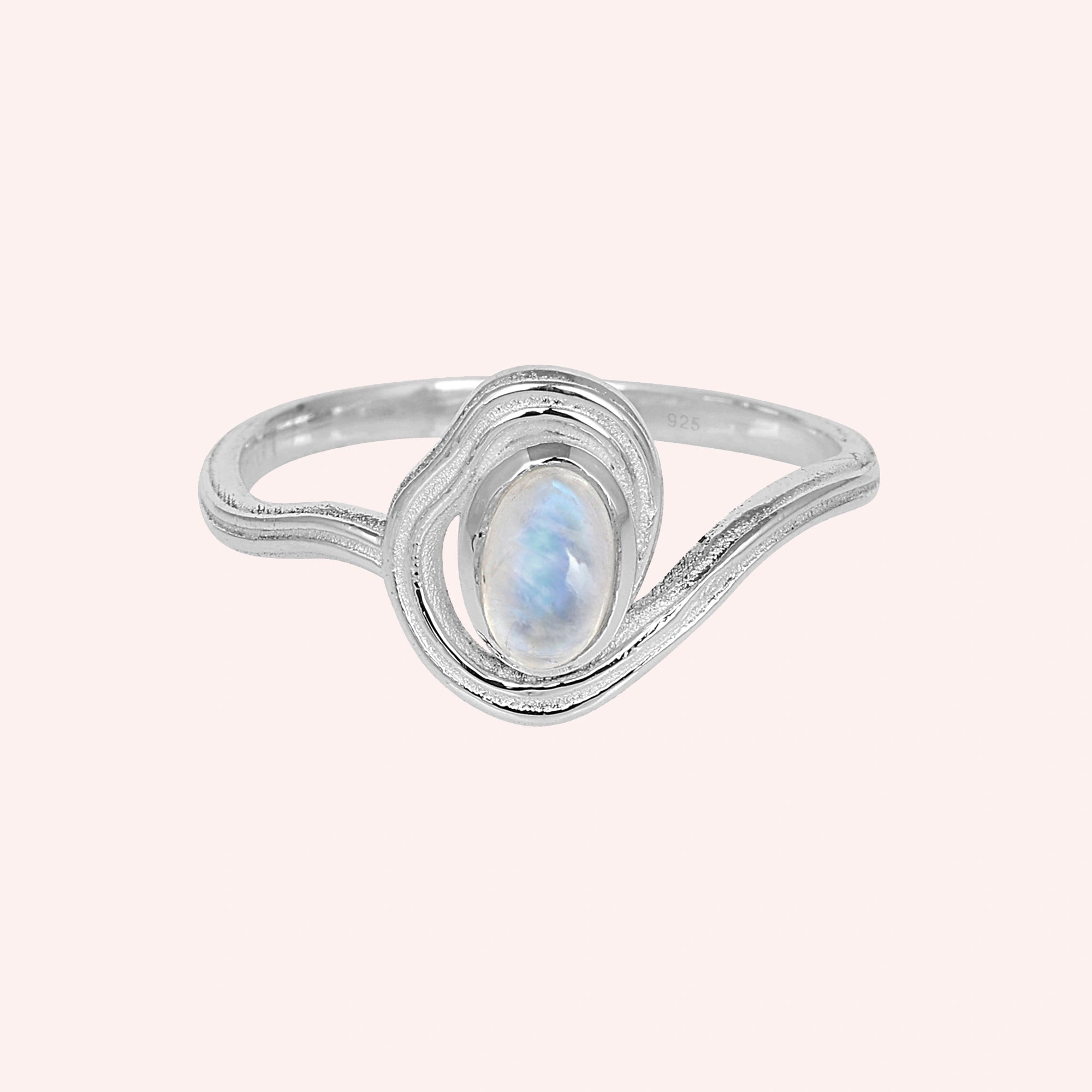 Moonstone_ring_with_sterling_silver_wave_band_at_front_angle_on_solid_pink_background