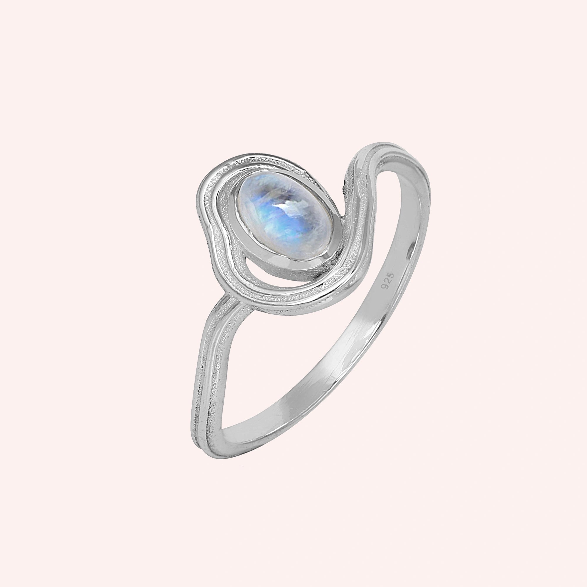 Moonstone_ring_with_sterling_silver_wave_band_at_side_angle_on_solid_pink_background