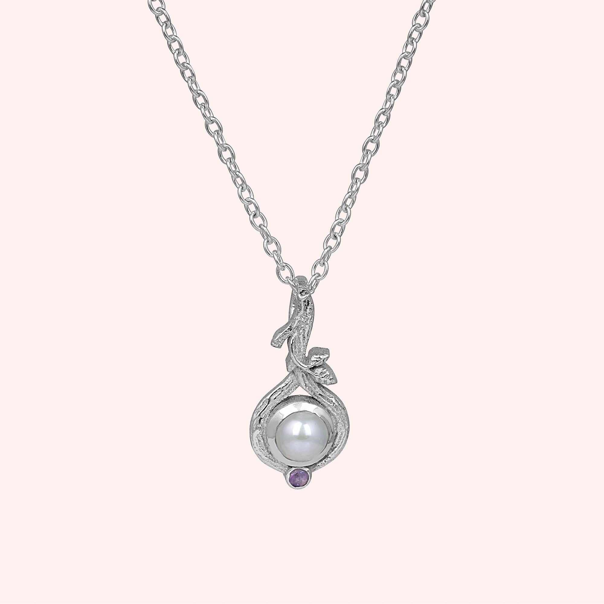 Front_view_silver_pearl_necklace_with_round_pearl_and_amethyst_accent_amethyst_pearl_necklace_on_soft_pink_background