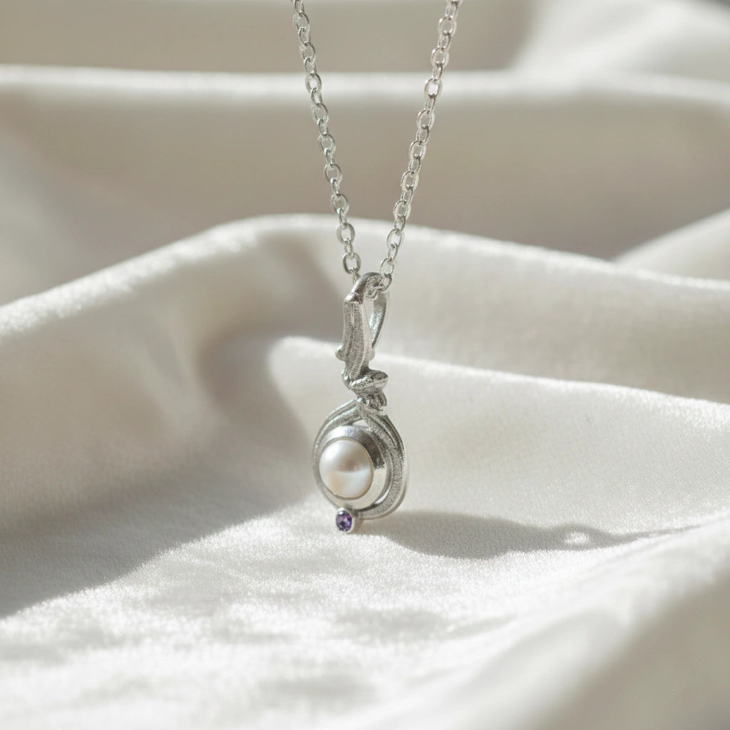 Side_angle_silver_pearl_necklace_with_round_pearl_and_amethyst_accent_amethyst_pearl_necklace_on_soft_satin_cloth_background