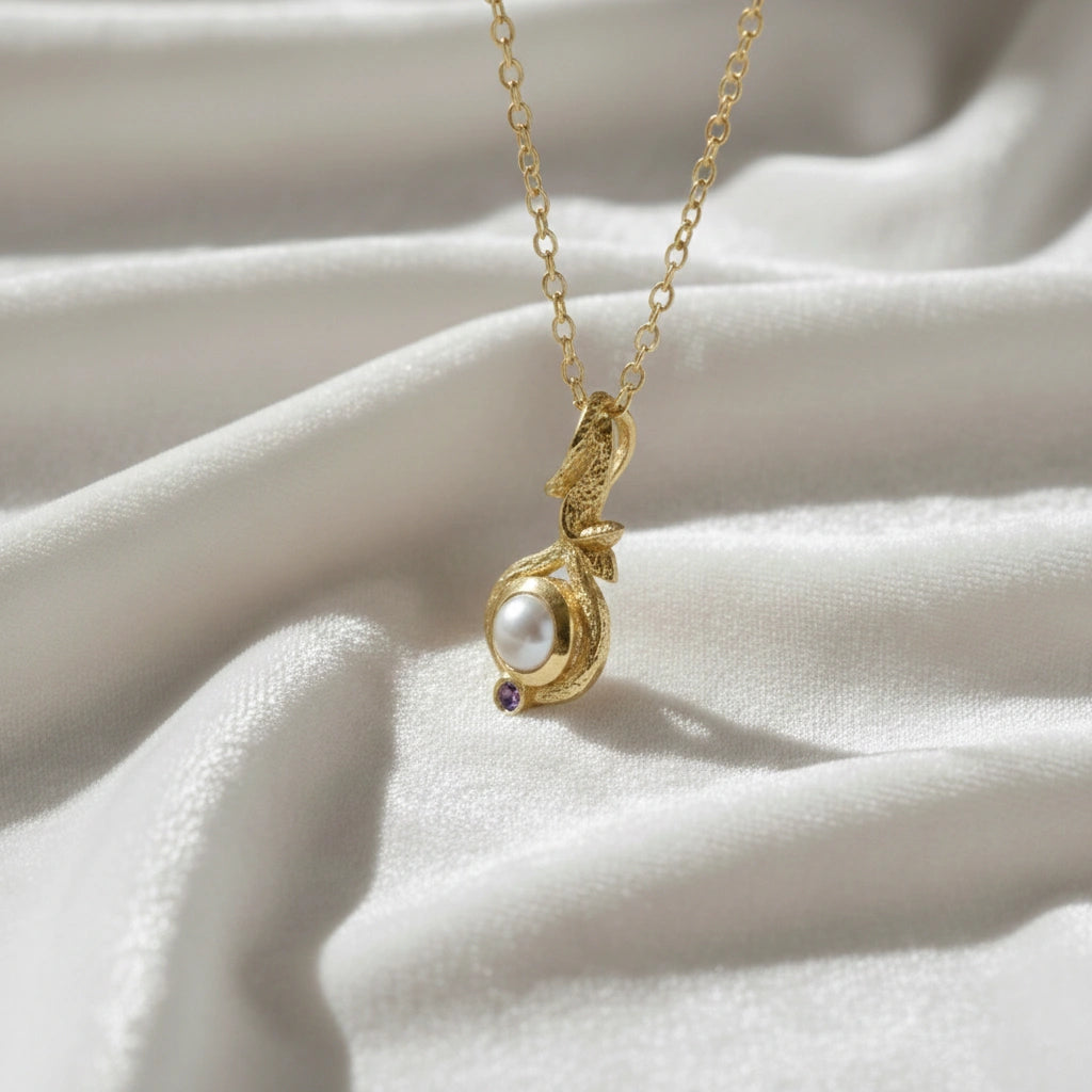 Front_angle_silver_pearl_necklace_with_gold_plated_chain_featuring_pearl_and_amethyst_pearl_necklace_on_silk_background