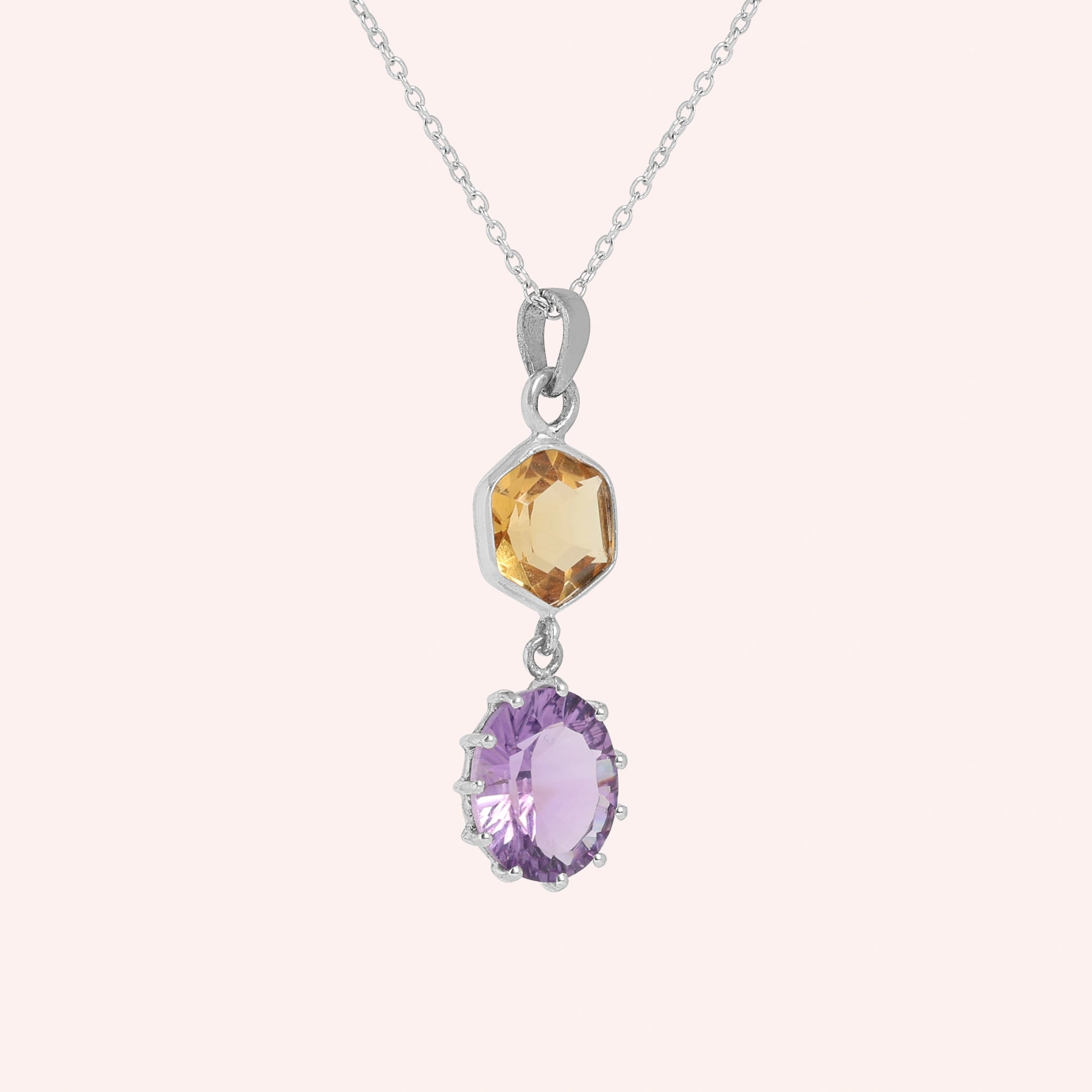 Silver_pendant_necklace_with_amethyst_and_citrine_stones_in_sterling_silver_at_slight_angle_view_on_solid_pink_background