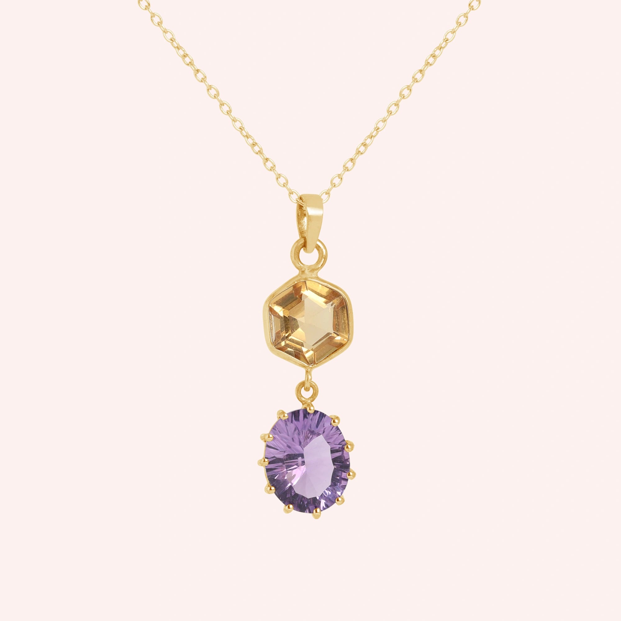 Silver_pendant_necklace_with_amethyst_and_citrine_stones_in_gold_plated_silver_at_front_angle_view_on_solid_pink_background