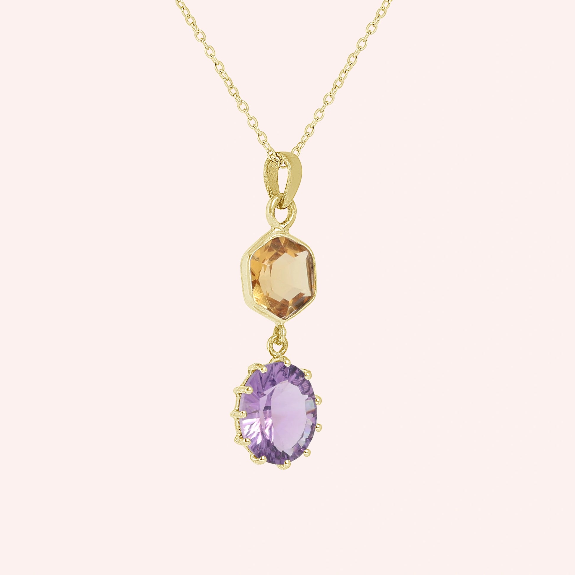 Silver_pendant_necklace_with_amethyst_and_citrine_stones_in_gold_plated_silver_at_slight_angle_view_on_solid_pink_background