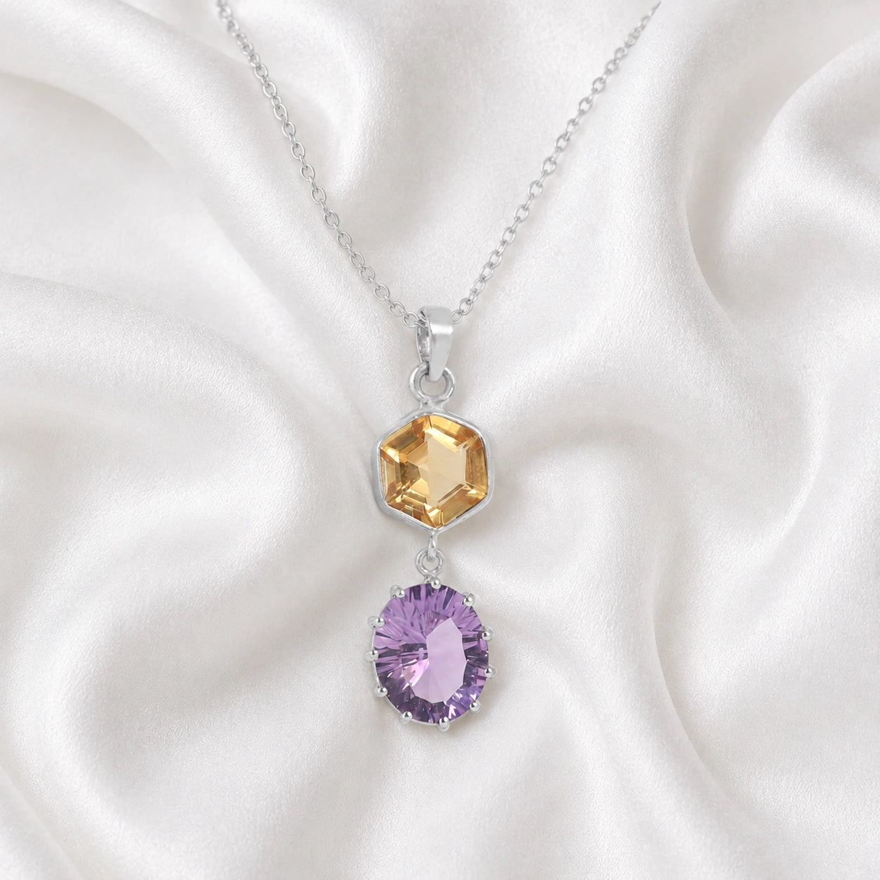 Silver_pendant_necklace_with_amethyst_and_citrine_stones_in_sterling_silver_at_front_angle_view_on_soft_fabric_background