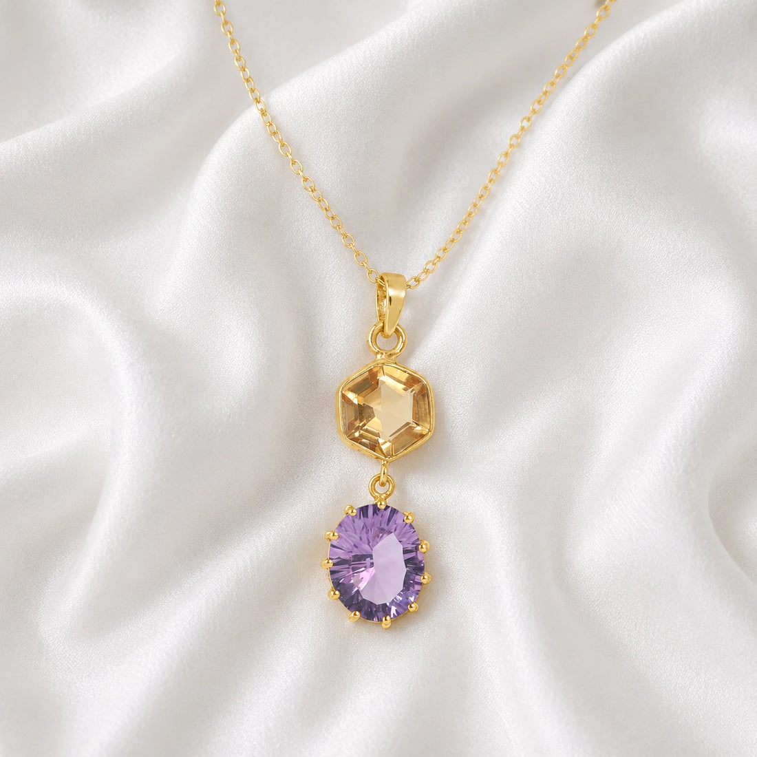 Silver_pendant_necklace_with_amethyst_and_citrine_stones_in_gold_plated_silver_at_front_angle_view_on_soft_fabric_background