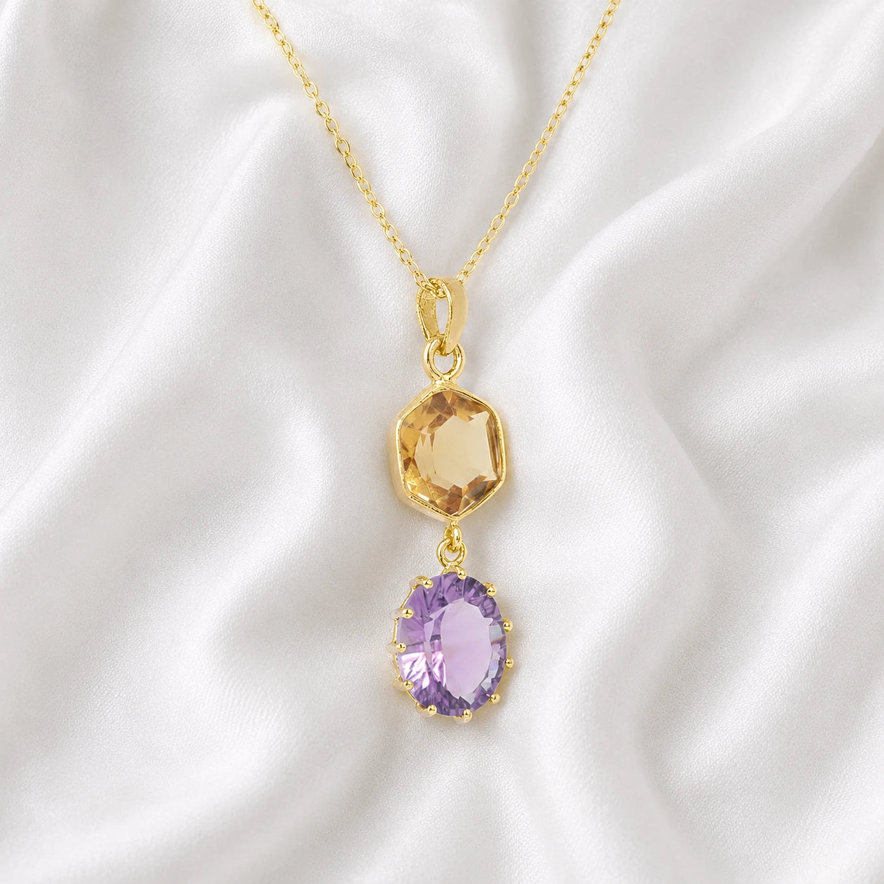 Silver_pendant_necklace_with_amethyst_and_citrine_stones_in_gold_plated_silver_at_slight_angle_view_on_soft_fabric_background