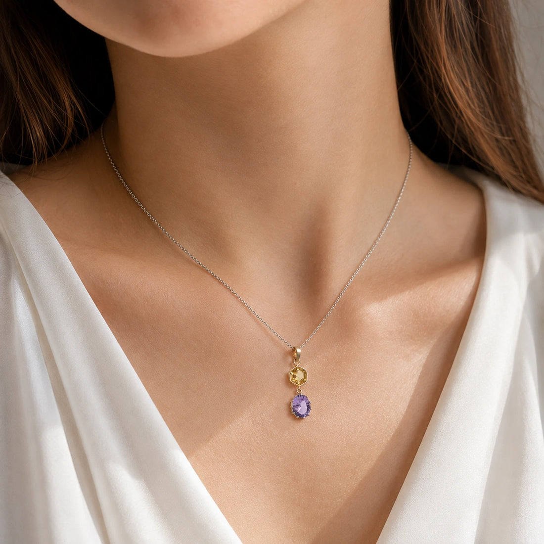 Silver_pendant_necklace_with_amethyst_and_citrine_stones_in_gold_plated_silver_at_front_angle_view_on_soft_fabric_background