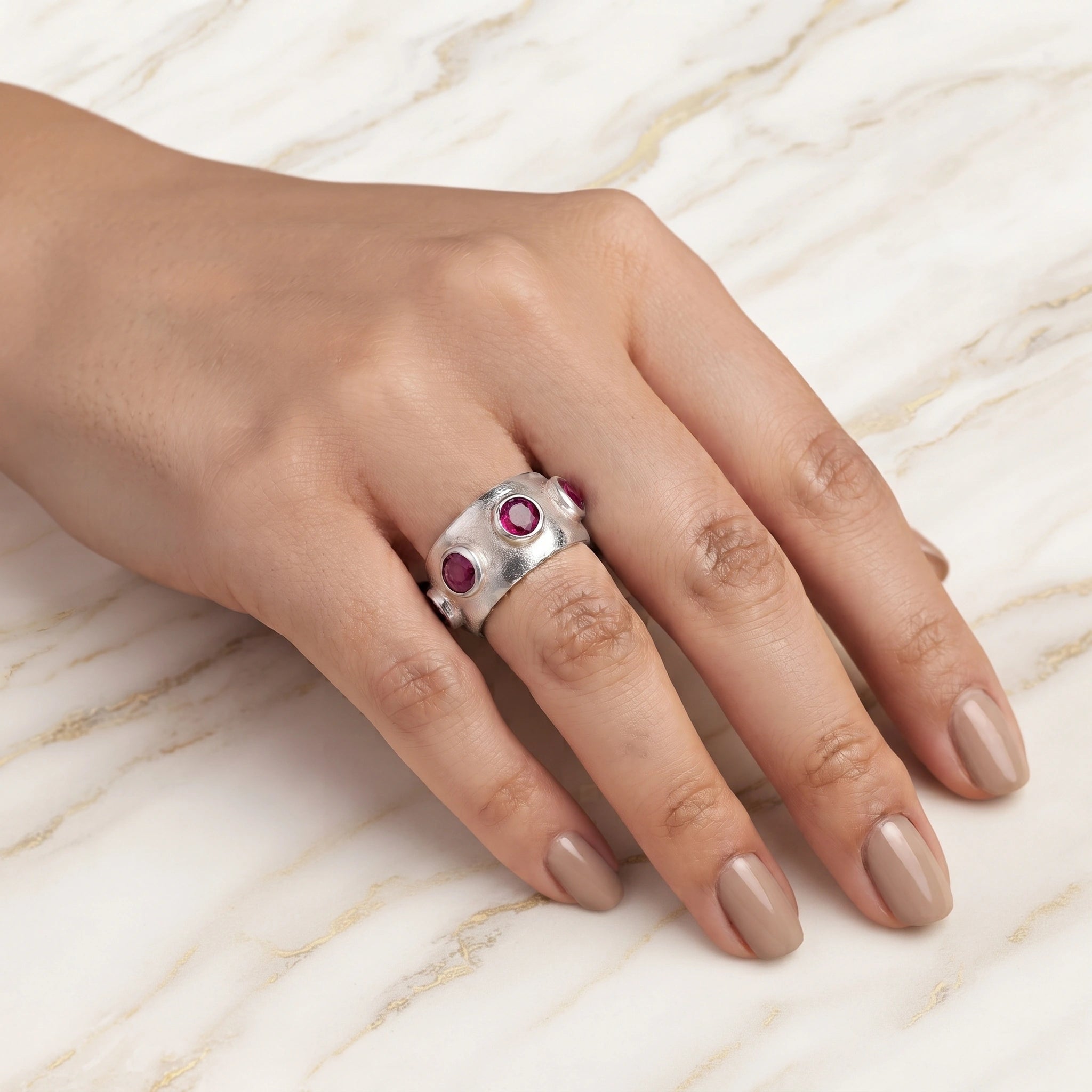 Silver_ruby_ring_in_sterling_silver_with_bezel_set_ruby_stones_worn_by_a_model