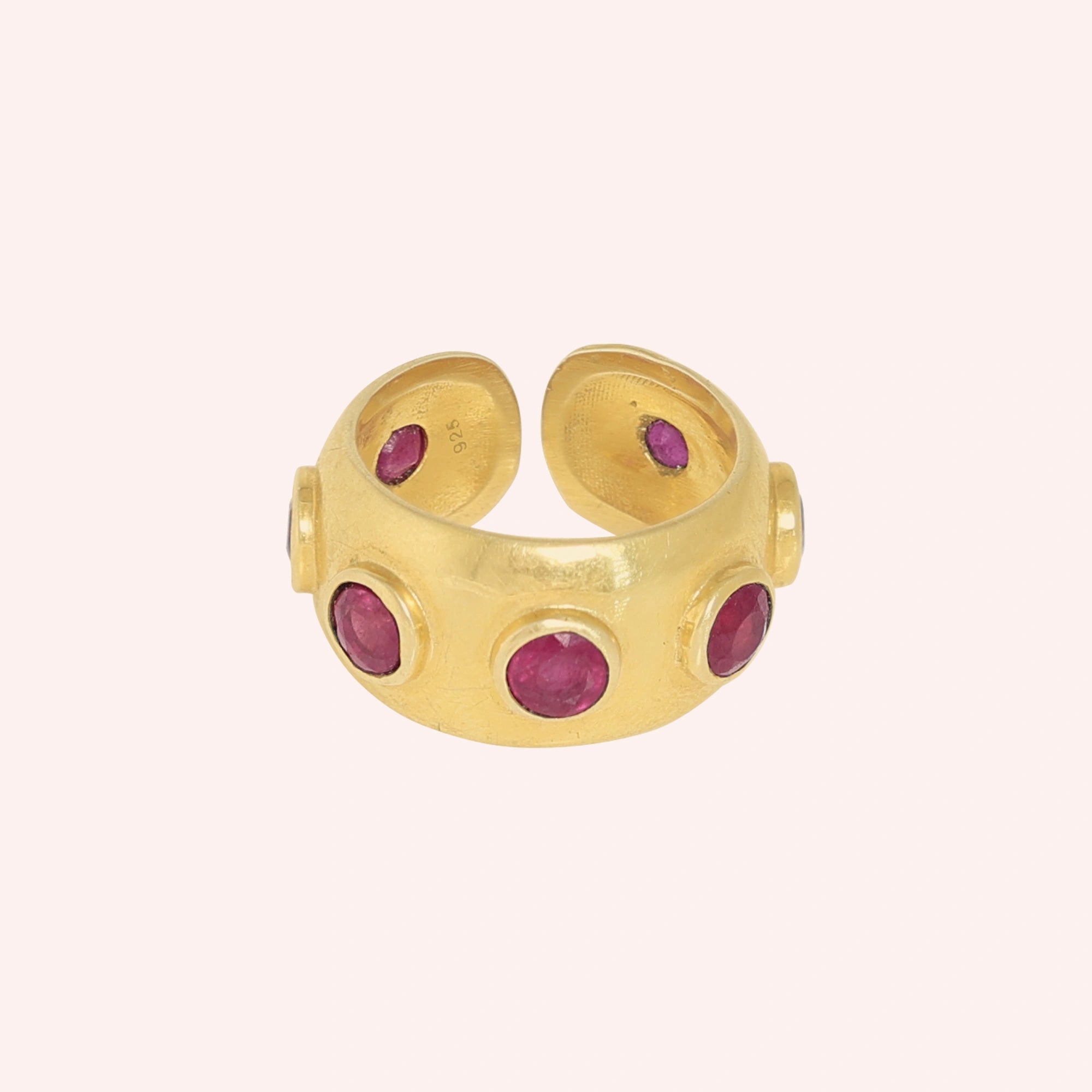 Silver_ruby_ring_in_gold_plated_silver_with_bezel_set_ruby_stones_at_front_view_on_solid_pink_background