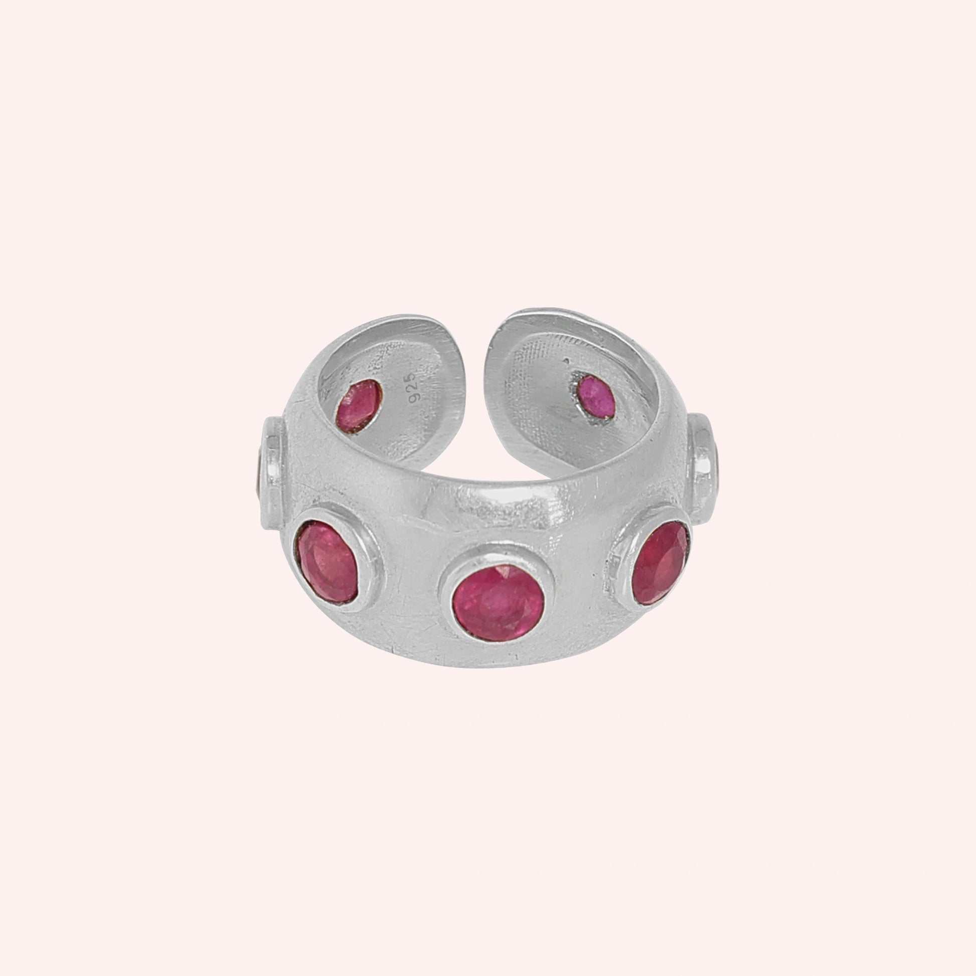 Silver_ruby_ring_in_sterling_silver_with_bezel_set_ruby_stones_at_front_view_on_solid_pink_background