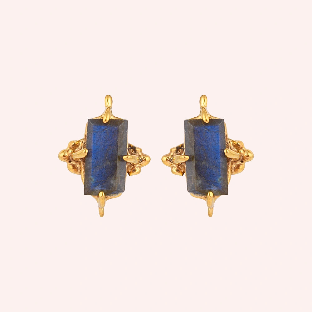 Silver_stud_earrings_in_gold_plated_silver_with_baguette_labradorite_stone_at_front_angle_view_on_solid_pink_background