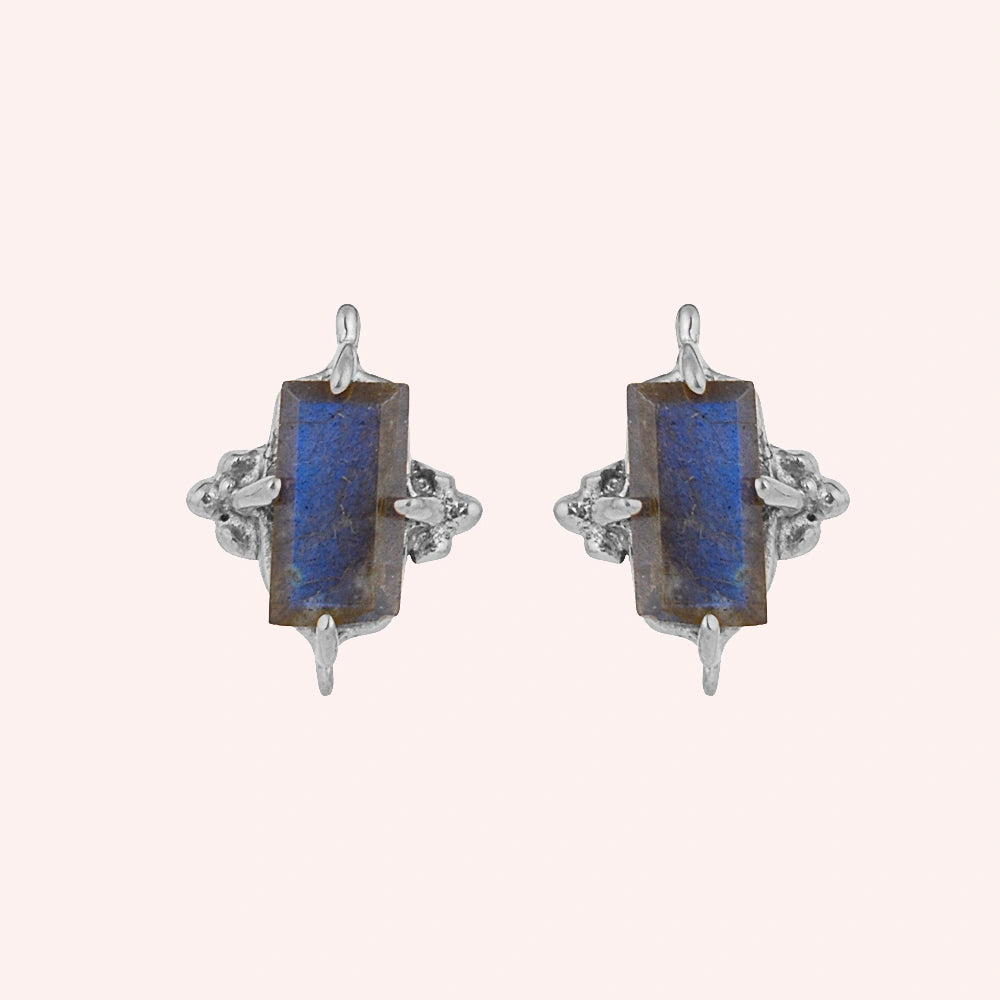Silver_stud_earrings_in_sterling_silver_with_baguette_labradorite_stone_at_front_angle_view_on_solid_pink_background