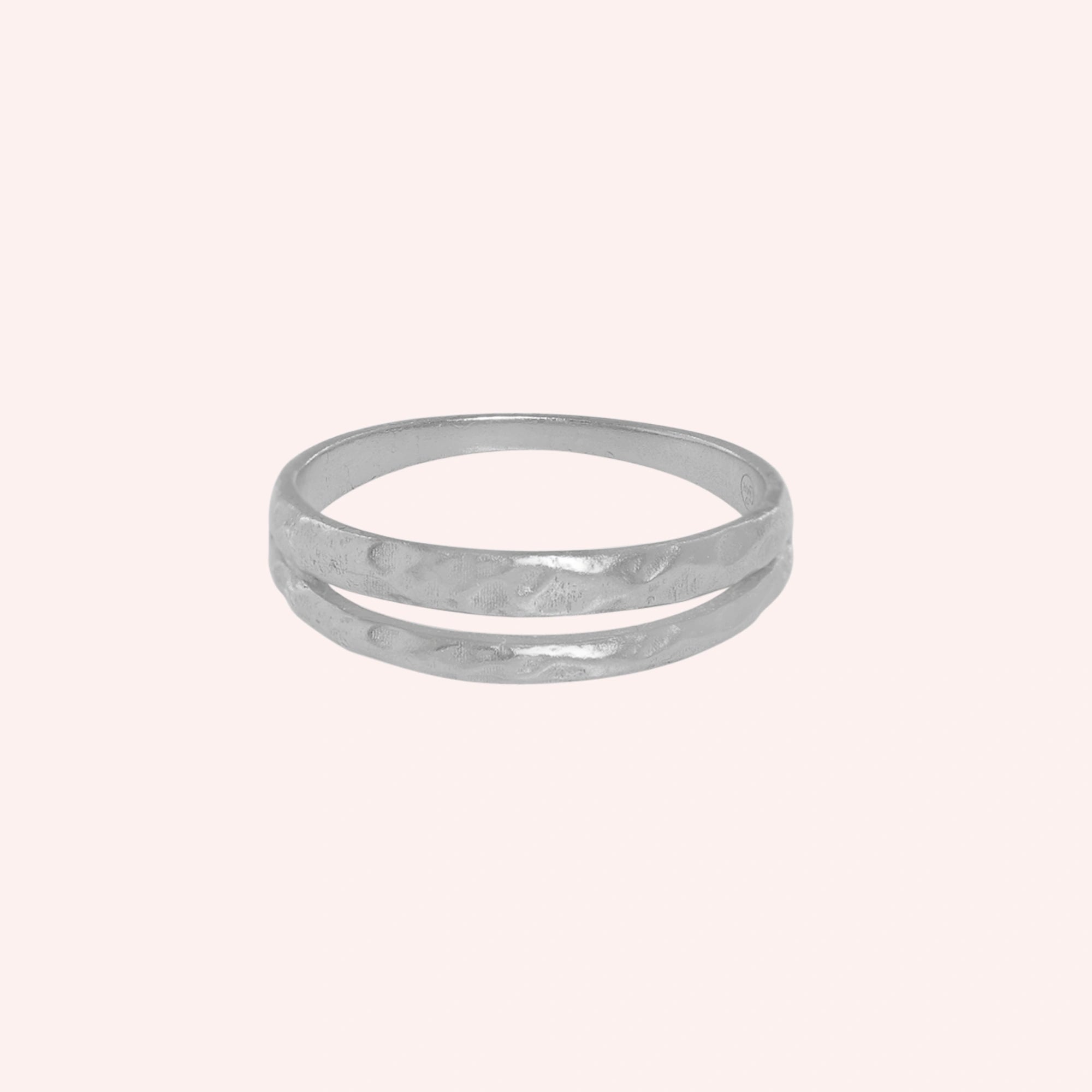 Simple_gold_ring_in_sterling_silver_with_split_band_at_front_angle_on_solid_pink_background