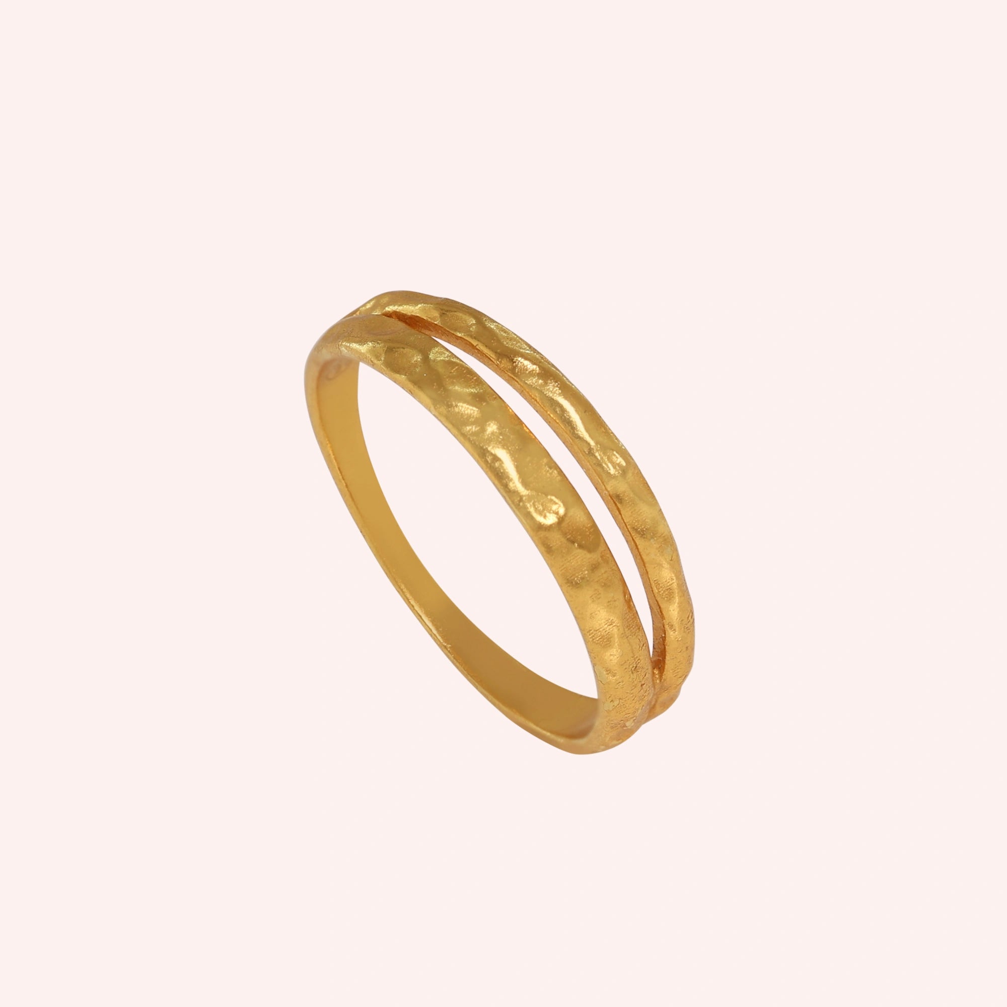 Simple_gold_ring_in_gold_plated_silver_with_split_band_at_angled_view_on_solid_pink_background