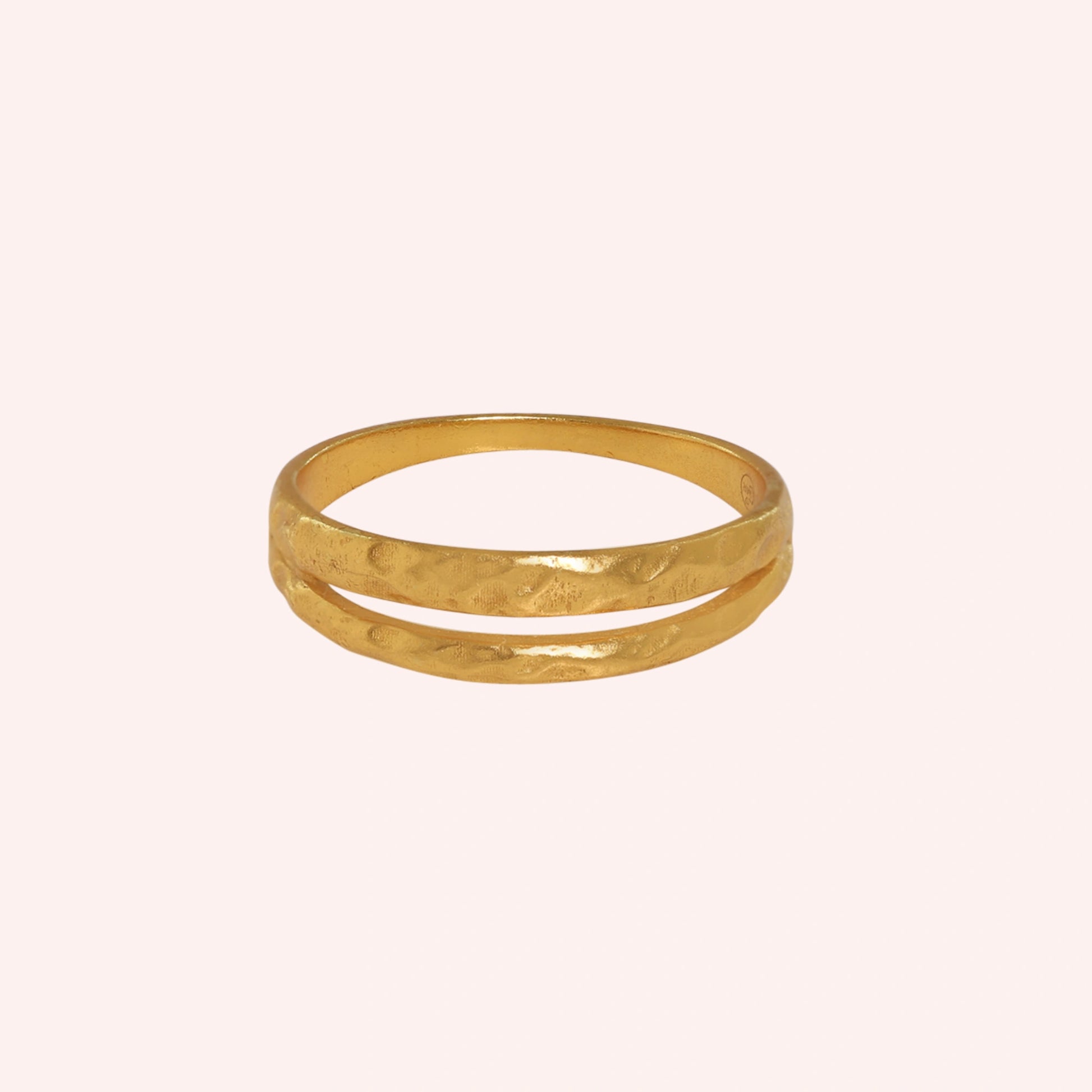 Simple_gold_ring_in_gold_plated_silver_with_split_band_at_front_angle_on_solid_pink_background