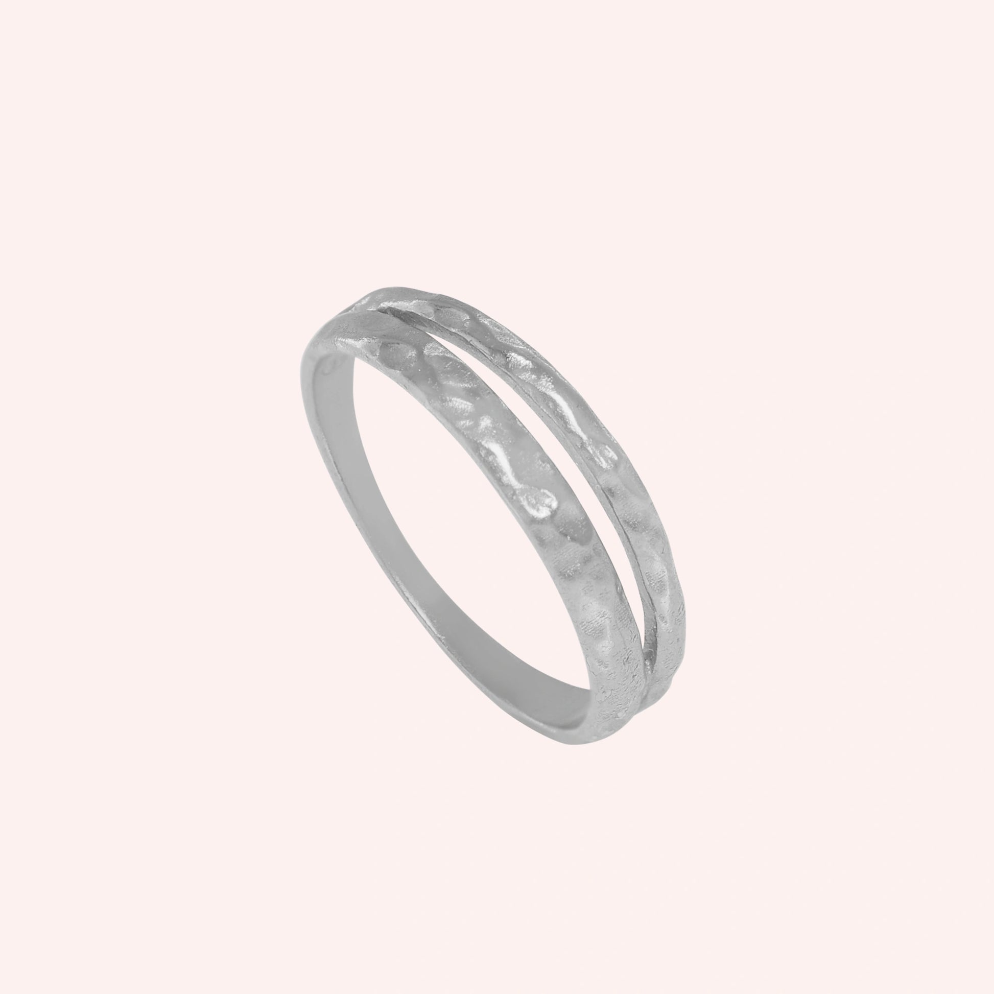 Simple_gold_ring_in_sterling_silver_with_split_band_at_angled_view_on_solid_pink_background