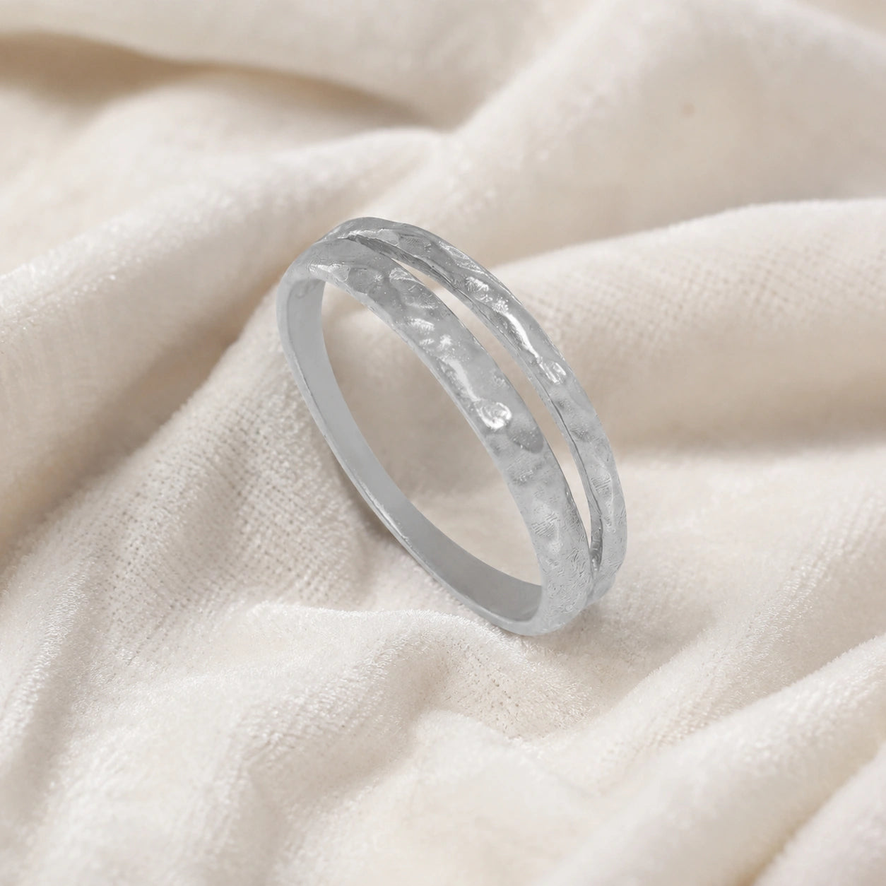 Simple_gold_ring_in_sterling_silver_with_split_band_at_slight_angle_on_soft_fabric_background