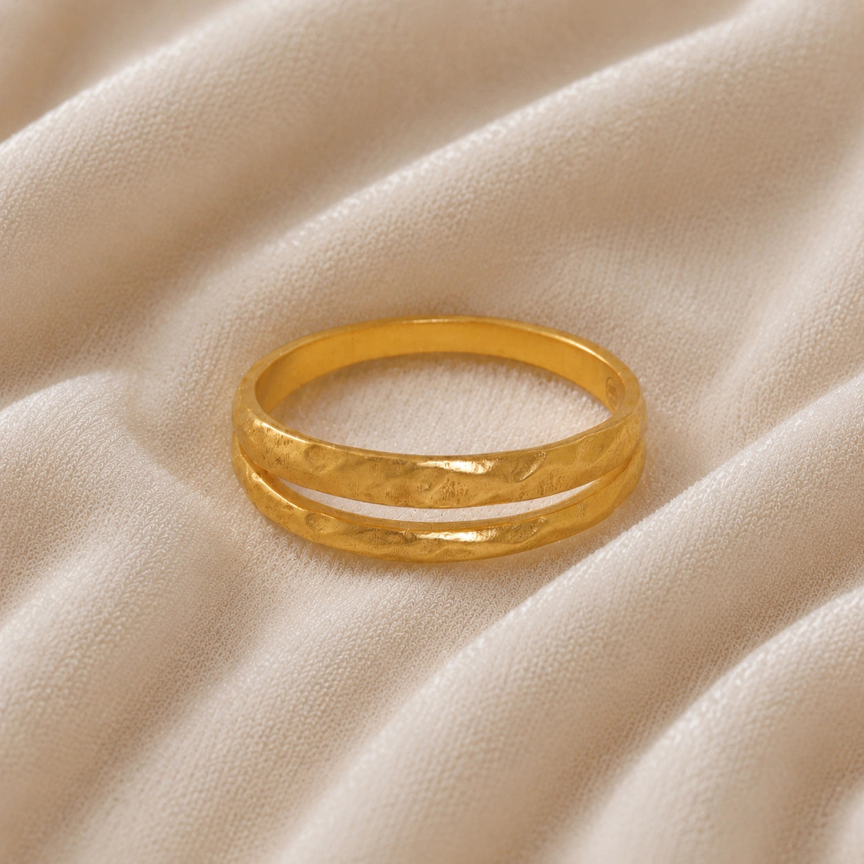 Simple_gold_ring_in_gold_plated_silver_with_split_band_at_front_angle_on_soft_fabric_background