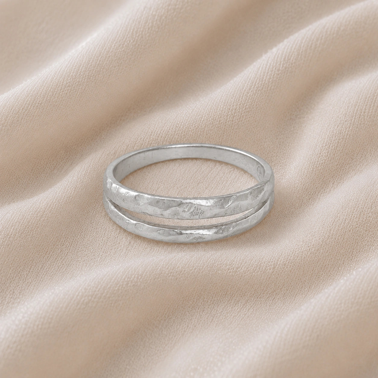 Simple_gold_ring_in_sterling_silver_with_split_band_at_front_angle_on_soft_fabric_background