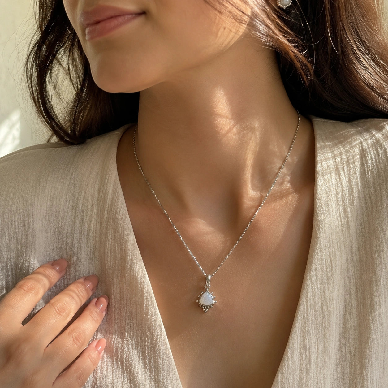 Simple_necklace_with_triangular_moonstone_pendant_sterling_silver_worn_by_a_model