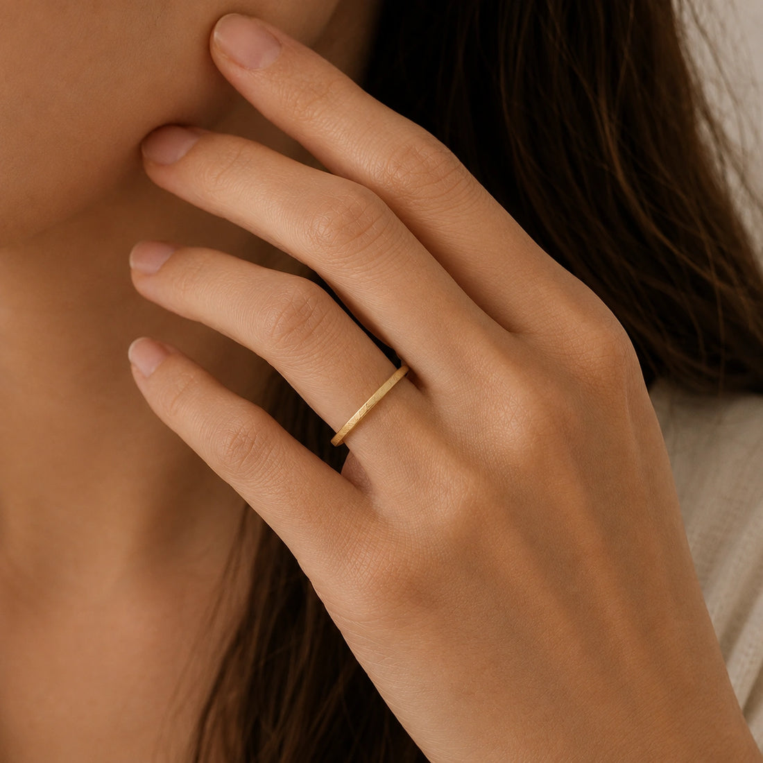 Simple_ring_in_gold_plated_silver_with_a_textured_band_at_front_angle_on_soft_fabric_background