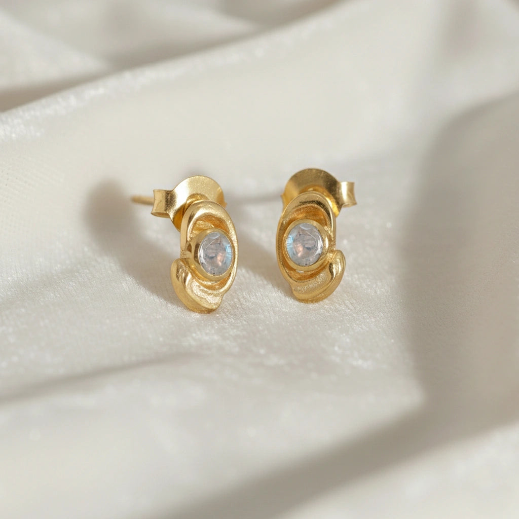 Small-stud-earrings-with-moonstone-gold-plated-silver-slight-angled-view-on-white-satin-background