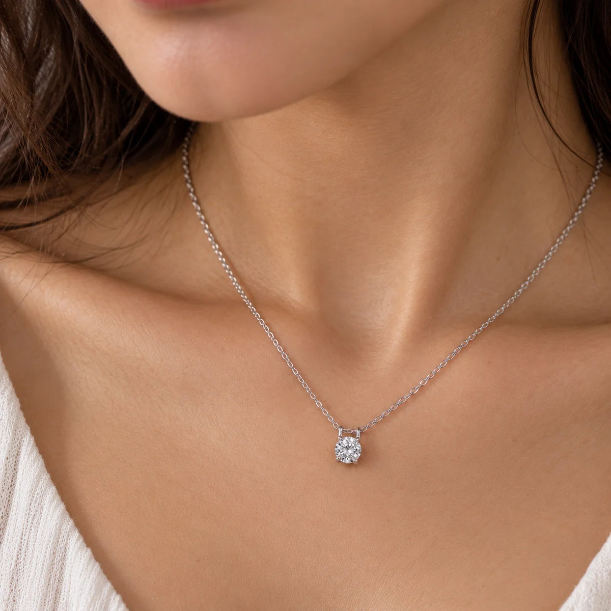 Solitaire_necklace_in_sterling_silver_with_a_round_lab_grown_diamond_at_front_angle_view_worn_by_a_model