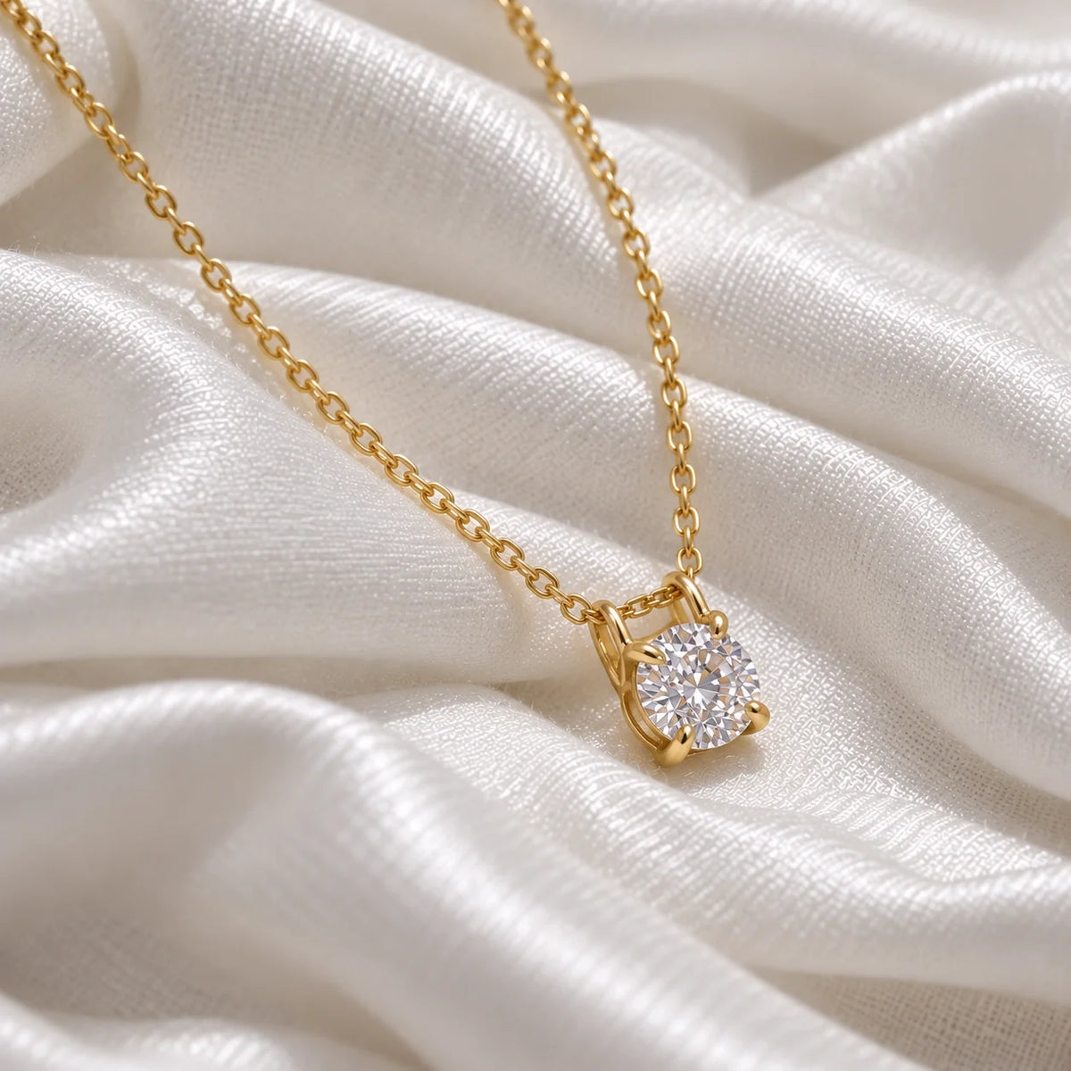 Solitaire_necklace_in_gold_plated_silver_with_a_round_lab_grown_diamond_at_side_angle_view_on_soft_fabric_background