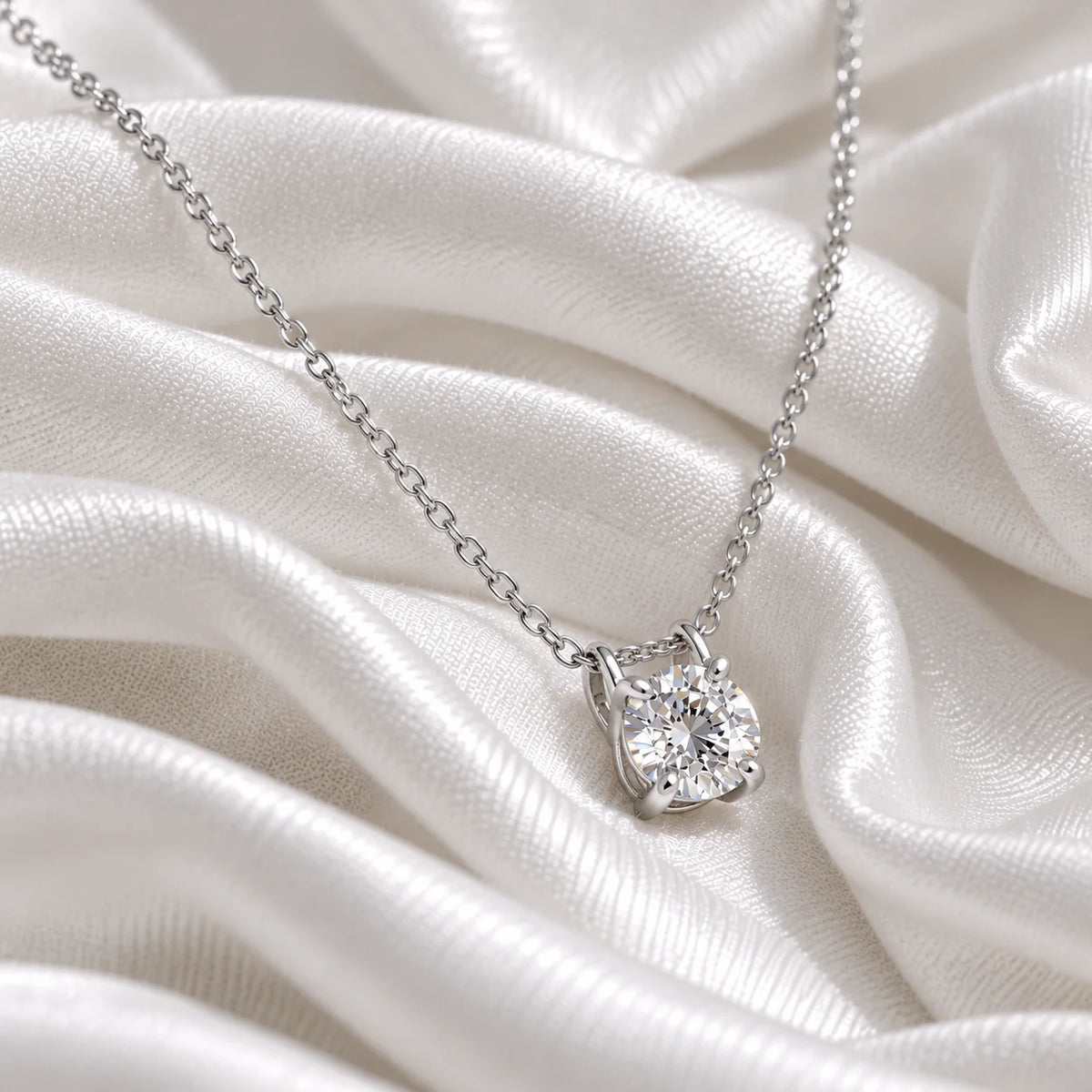 Solitaire_necklace_in_sterling_silver_with_a_round_lab_grown_diamond_at_side_angle_view_on_soft_fabric_background