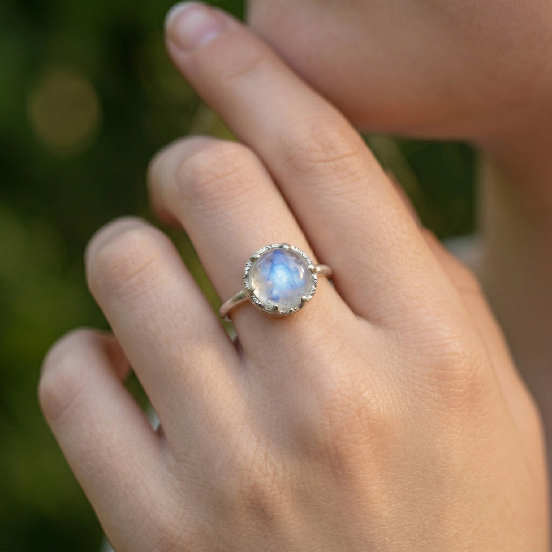 Solitaire_ring_in_gold_plated_ring_with_round_moonstone_shown_in_front_angle_view_on_soft_fabric_background