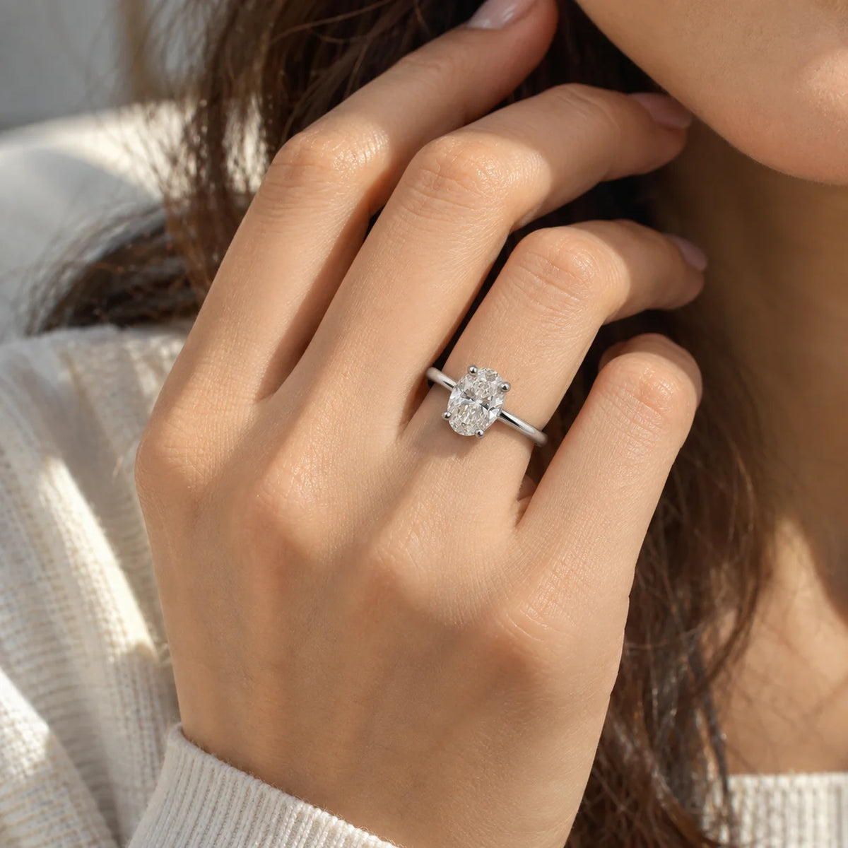 Solitaire_ring_in_sterling_silver_with_an_oval_lab_grown_diamond_at_front_angle_view_on_solid_pink_background