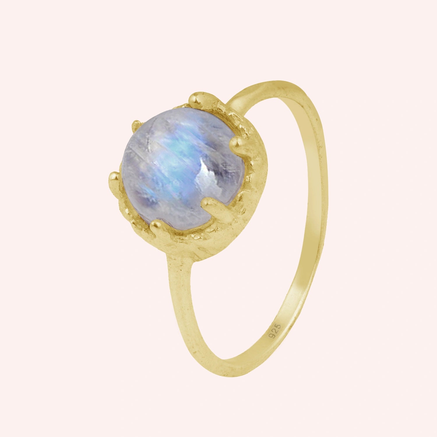 Solitaire_ring_in_gold_plated_ring_with_round_moonstone_shown_in_slightly_angled_view_on_solid_pink_background