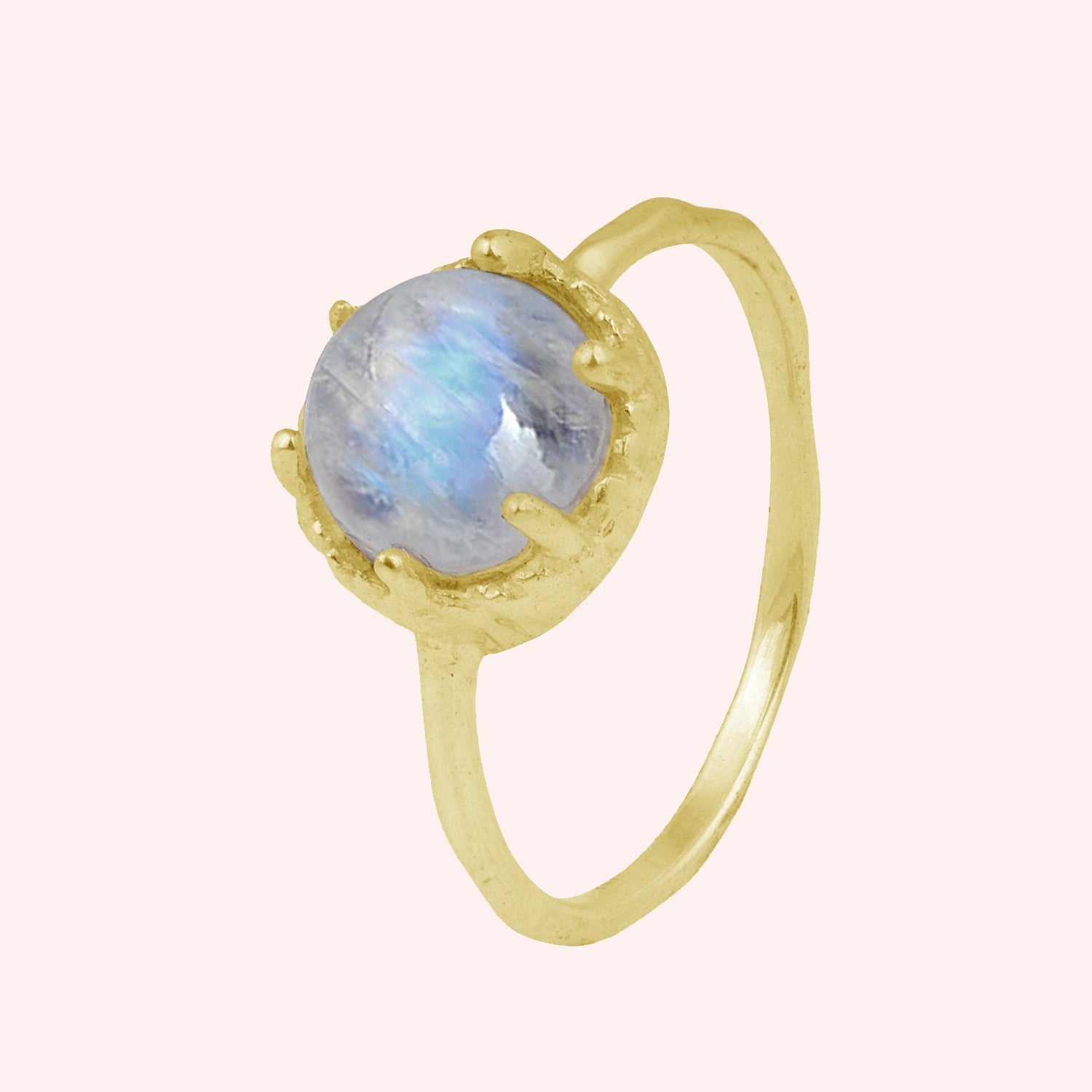 Solitaire_ring_in_gold_plated_ring_with_round_moonstone_shown_in_slightly_angled_view_on_solid_pink_background